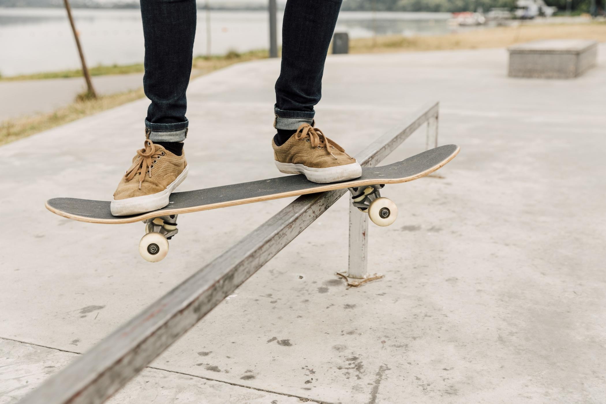 Une personne  est en train de skater sur un rail dans un skatepark.