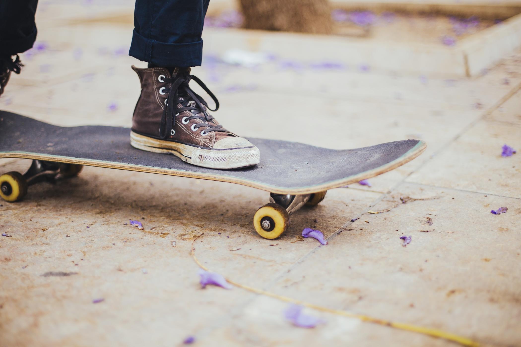 Deux pieds sont posés sur un skateboard.
