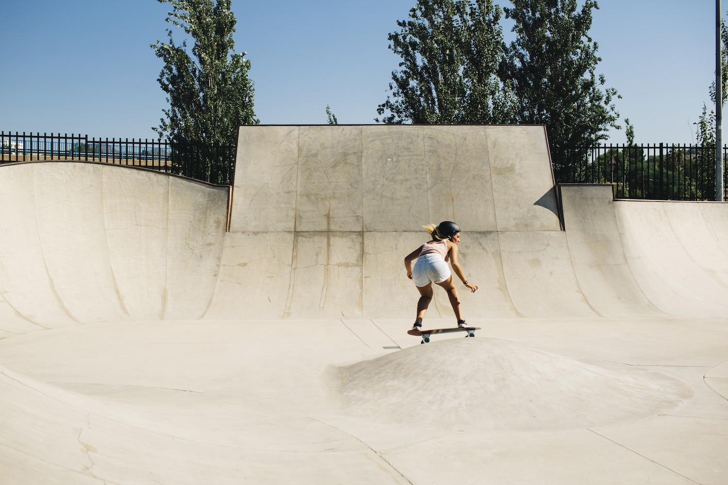 Une jeune femme fait du skate dans un skatepark.