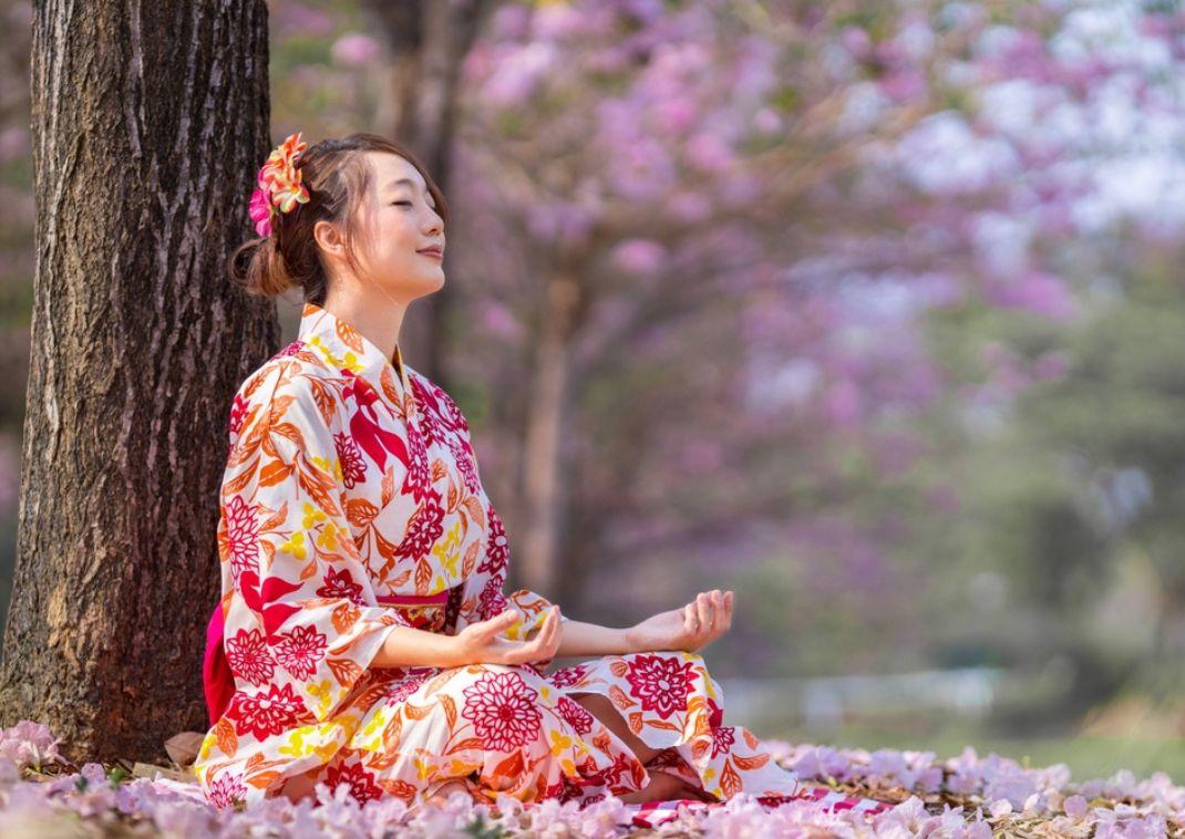 Une femme japonaise en pleine méditation en extérieur