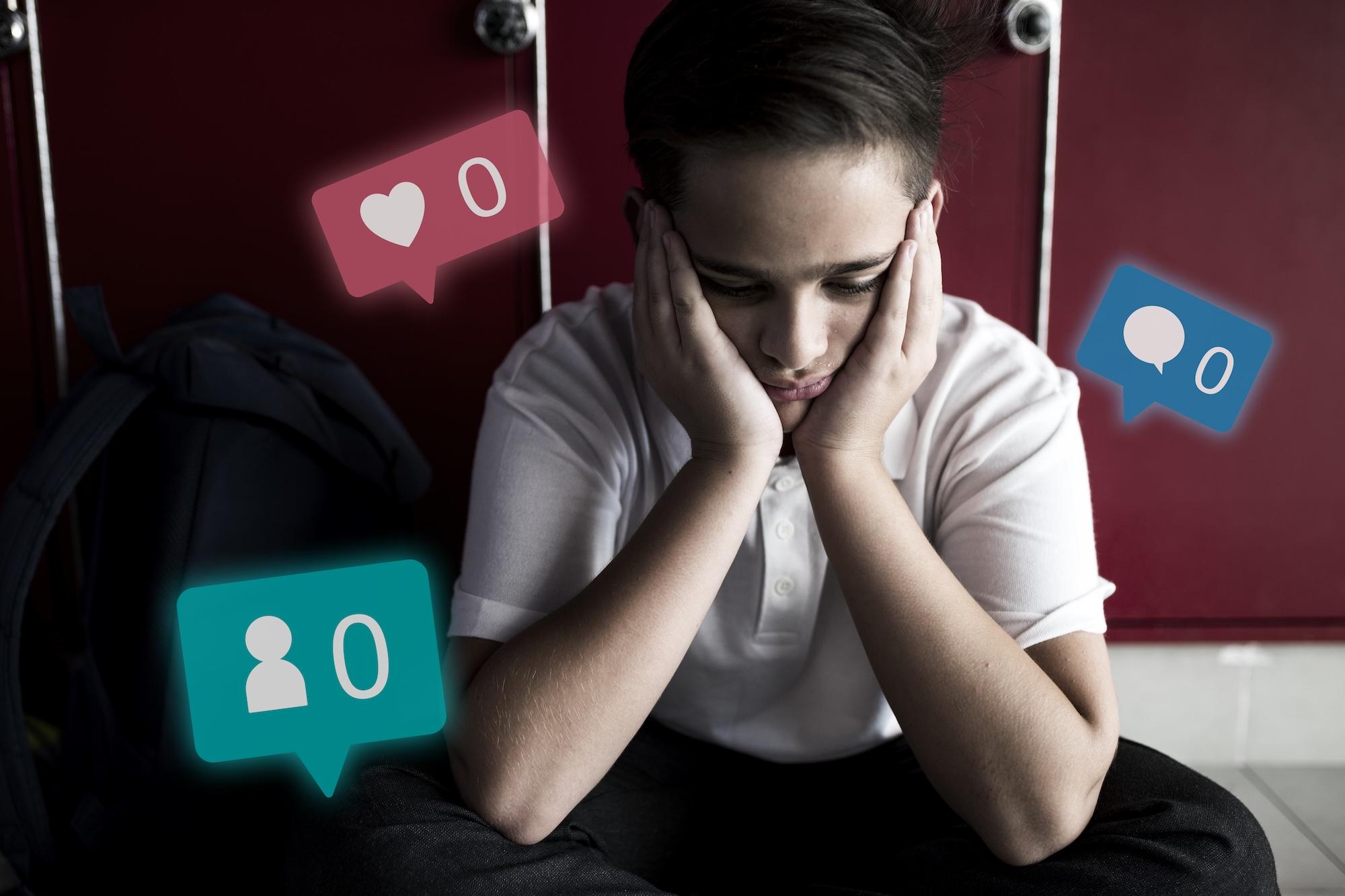 Un jeune garçon triste est assis la tête dans les mains