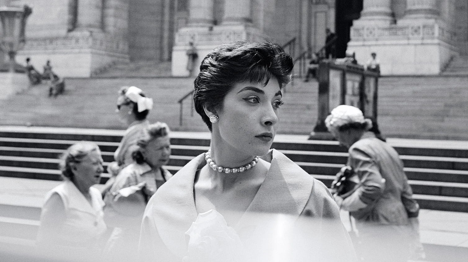 Jeune femme bien habillée prise en photo dans la rue par Vivian Maier. 