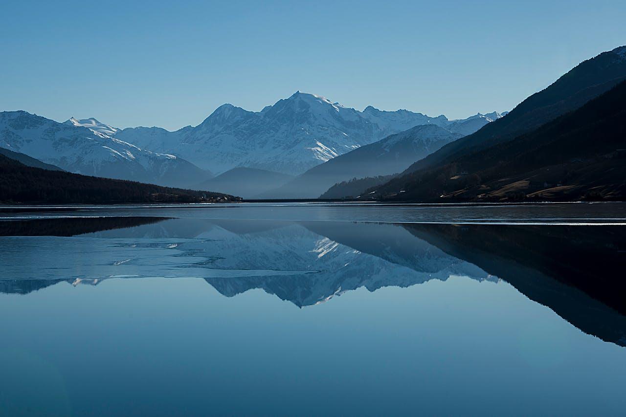 Montagnes se reflétant dans l'eau d'un lac.