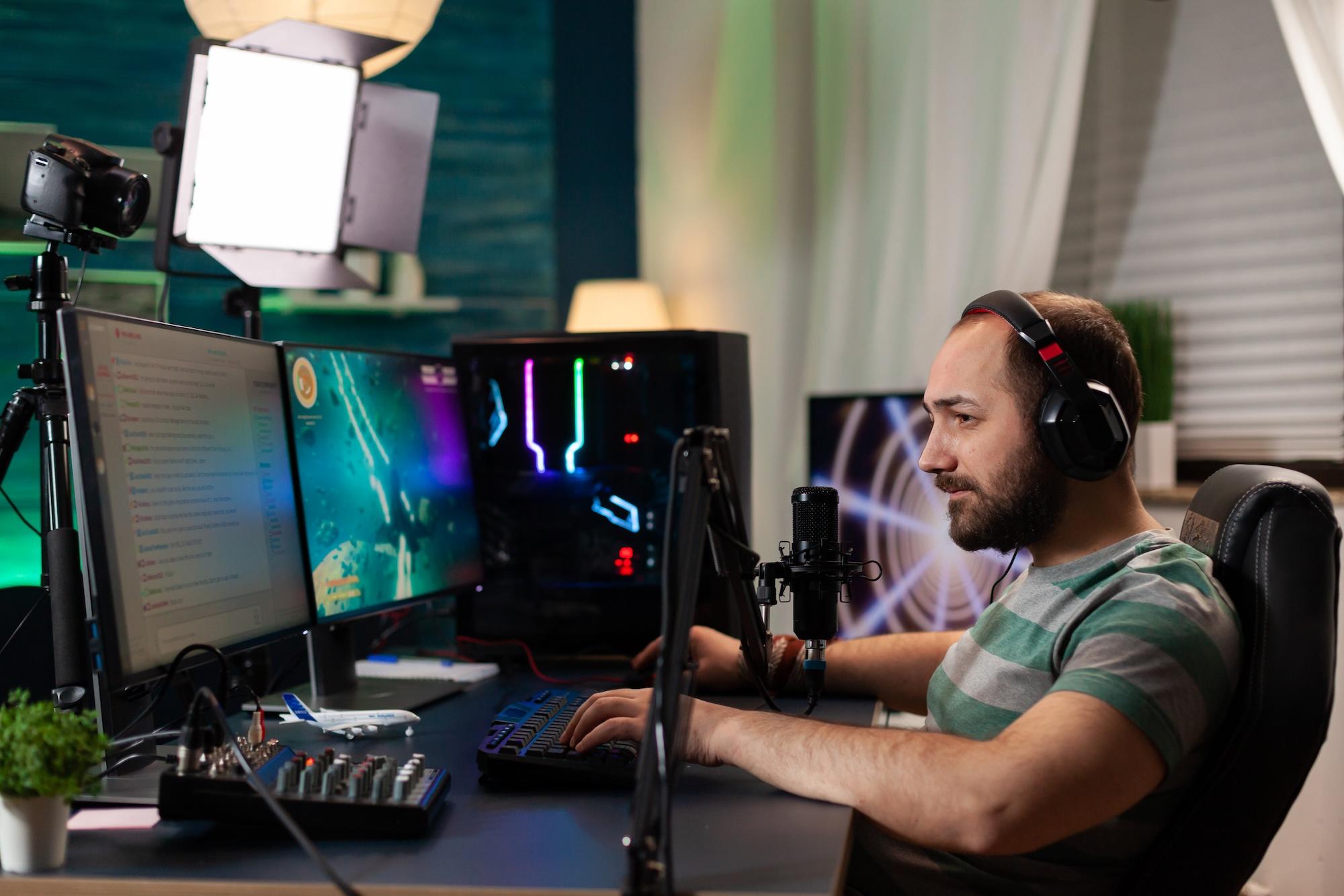 Un streamer est devant son ordinateur en train de jouer à un jeu vidéo.