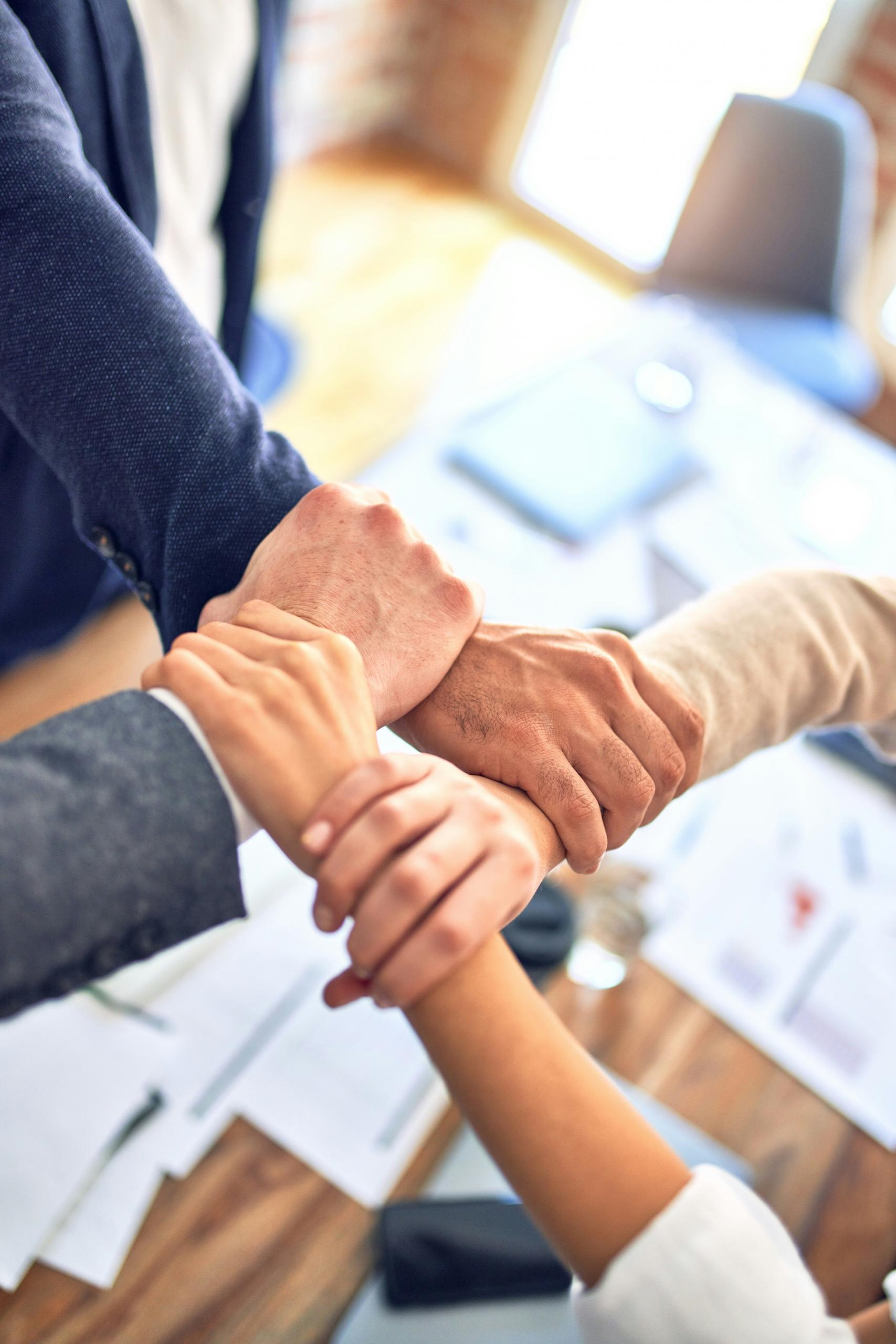 Une équipe d'entrepreneurs se prend par le bras.