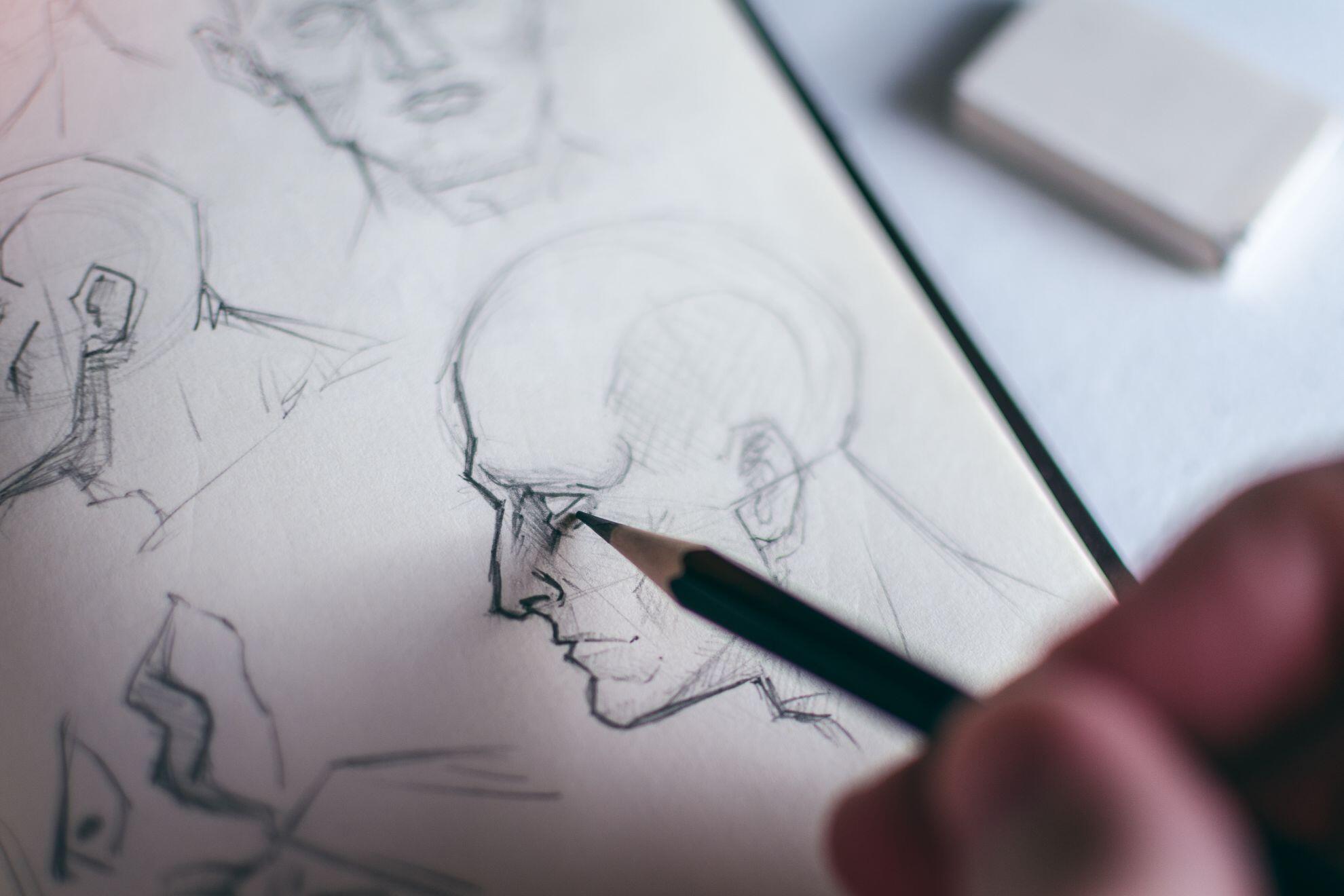 Un homme en train de dessiner un visage de profil.