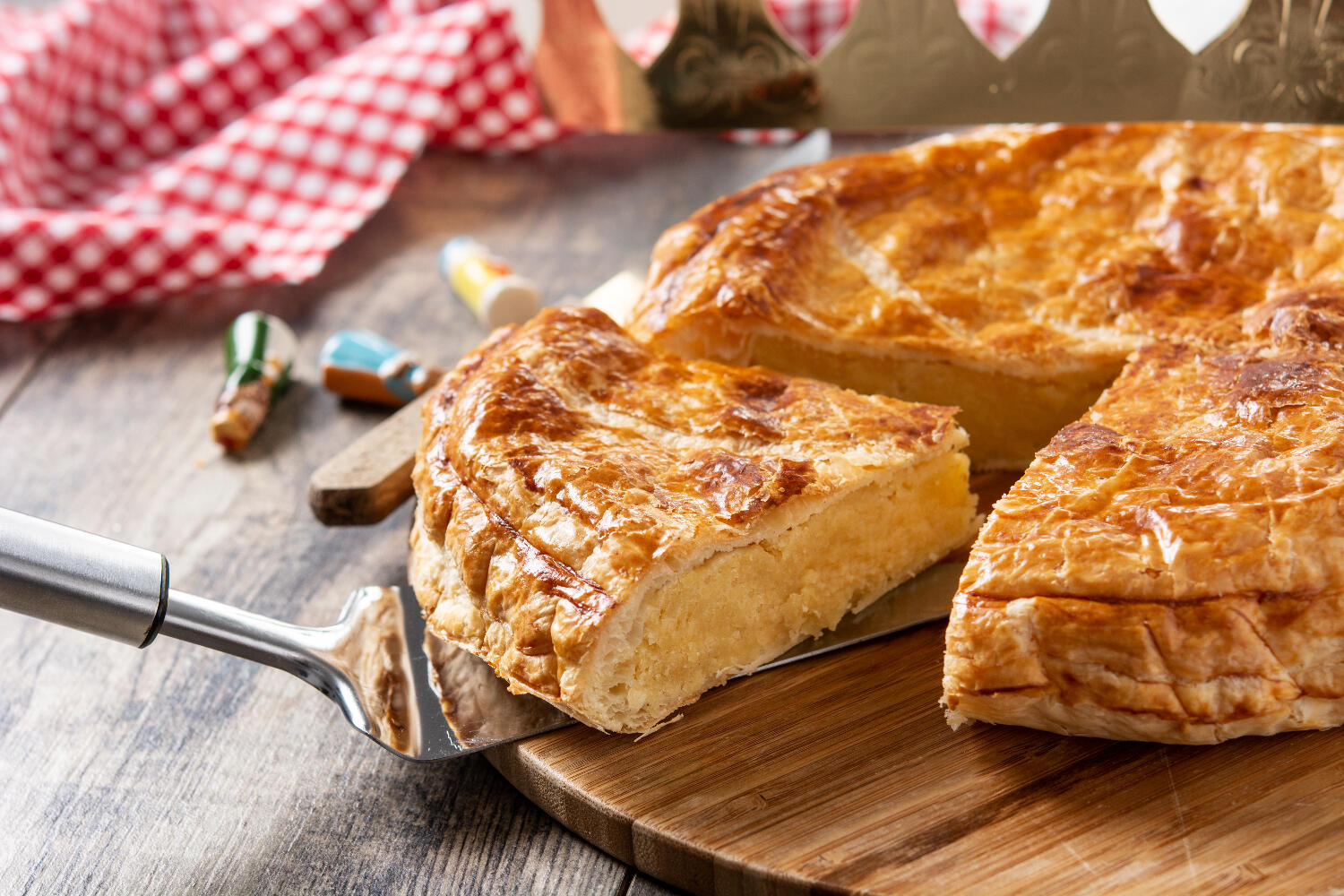 Une belle galette des rois remplie de frangipane découpée en parts.