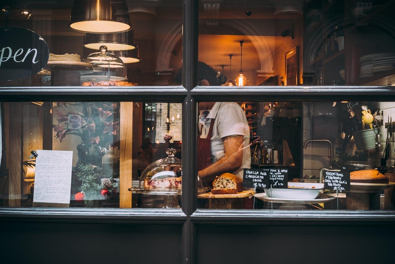 Vue d'une vitrine de boulangerie-pâtisserie depuis la rue. 