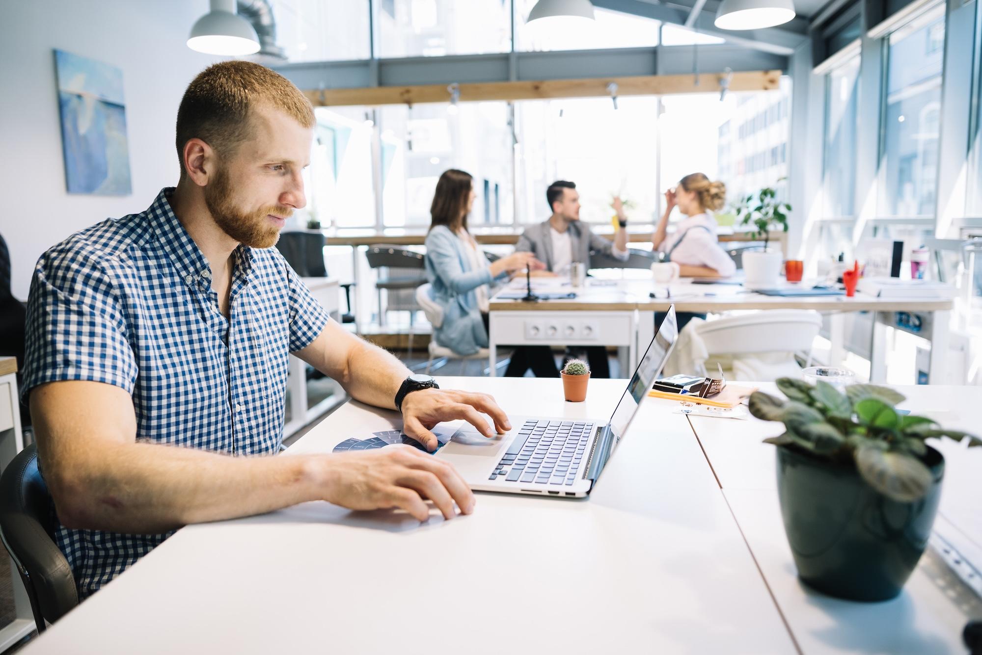 Homme pensif devant un ordinateur portable au bureau