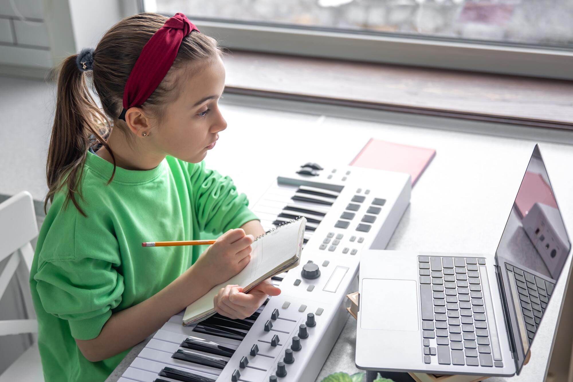 Une petite fille est en train d'apprendre le piano