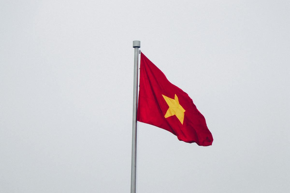 Drapeau vietnamien flottant dans un ciel gris.