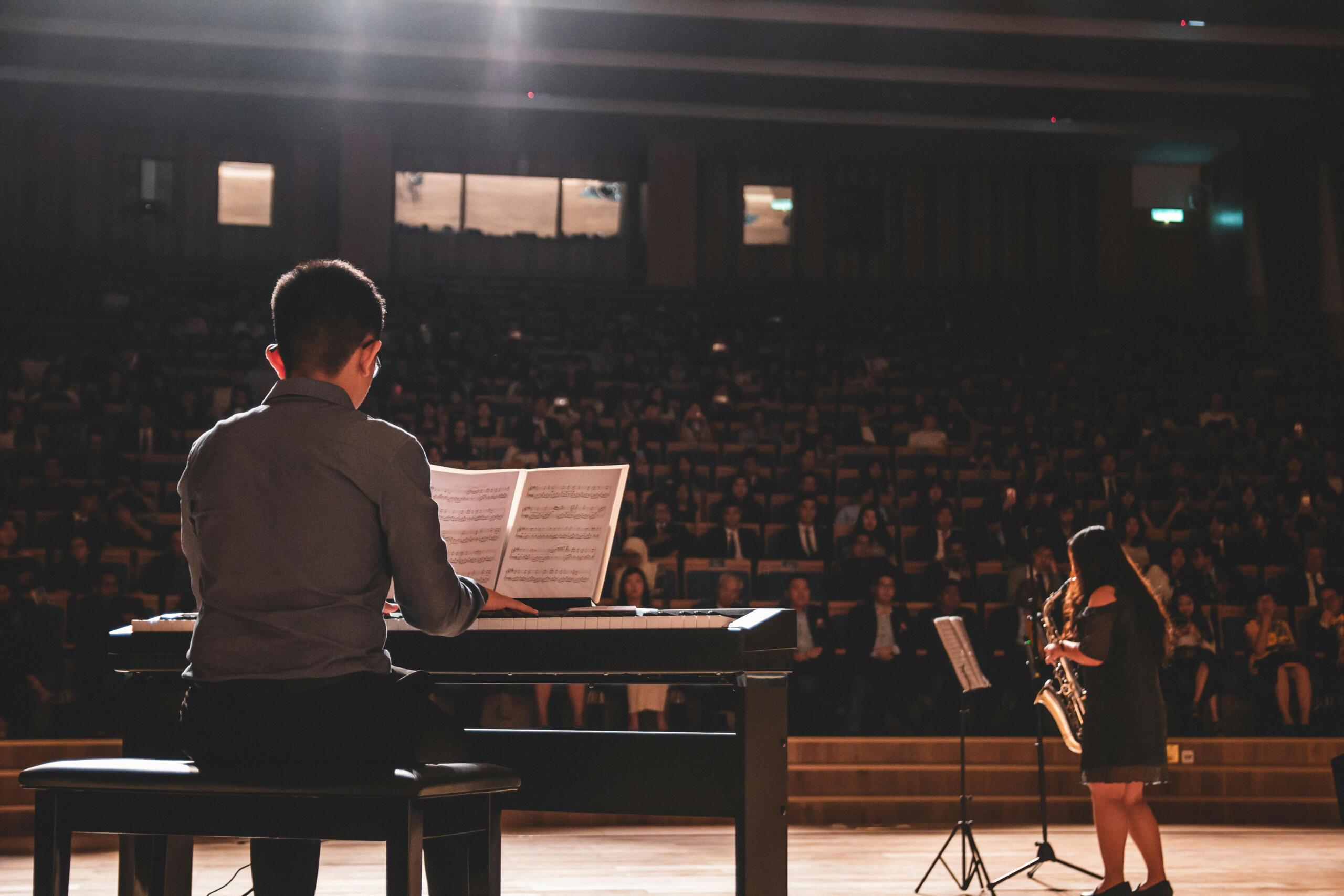 Un concert de piano et de saxophone sur scène.