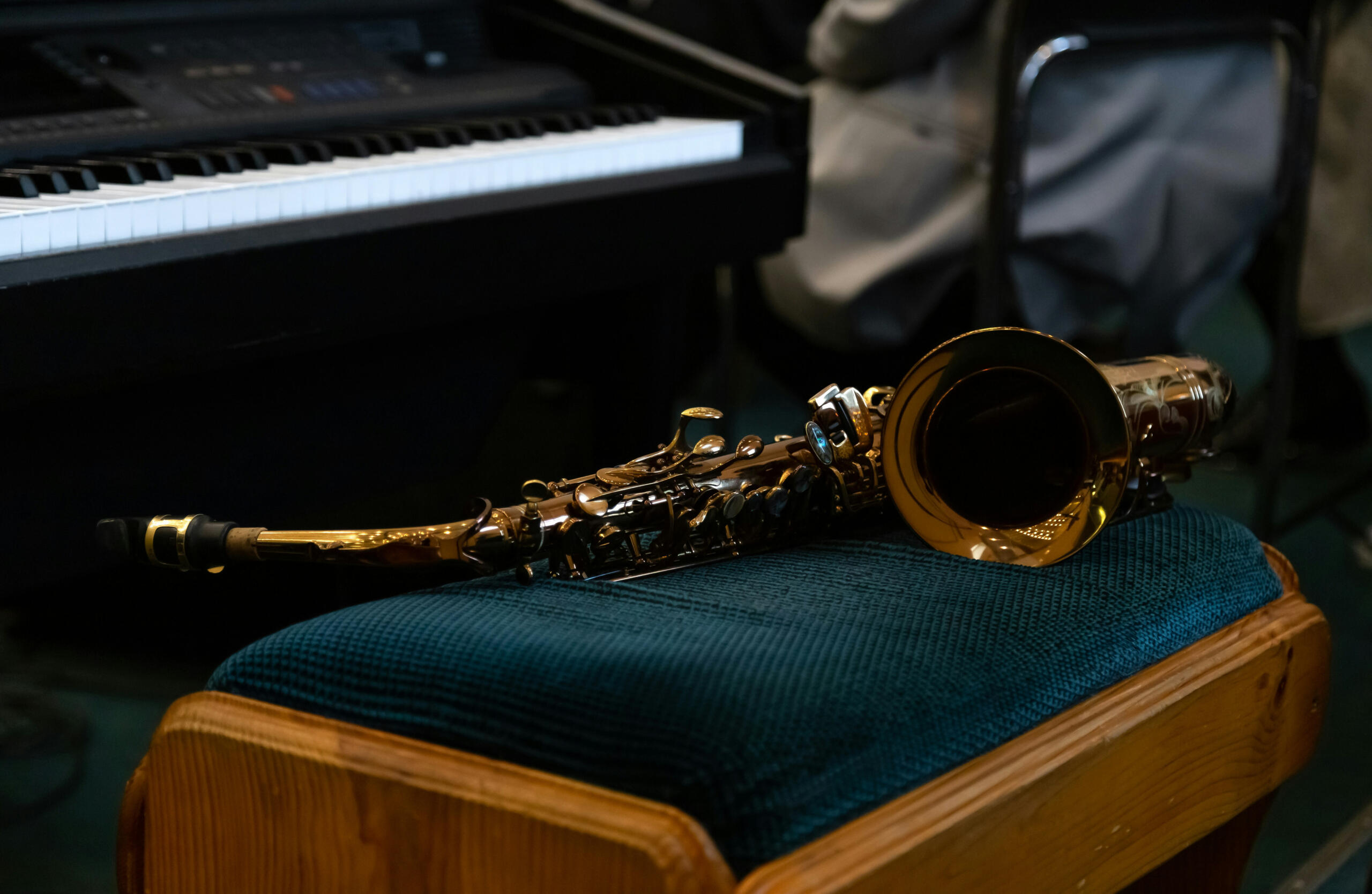 Un saxophone alto posé devant un piano.
