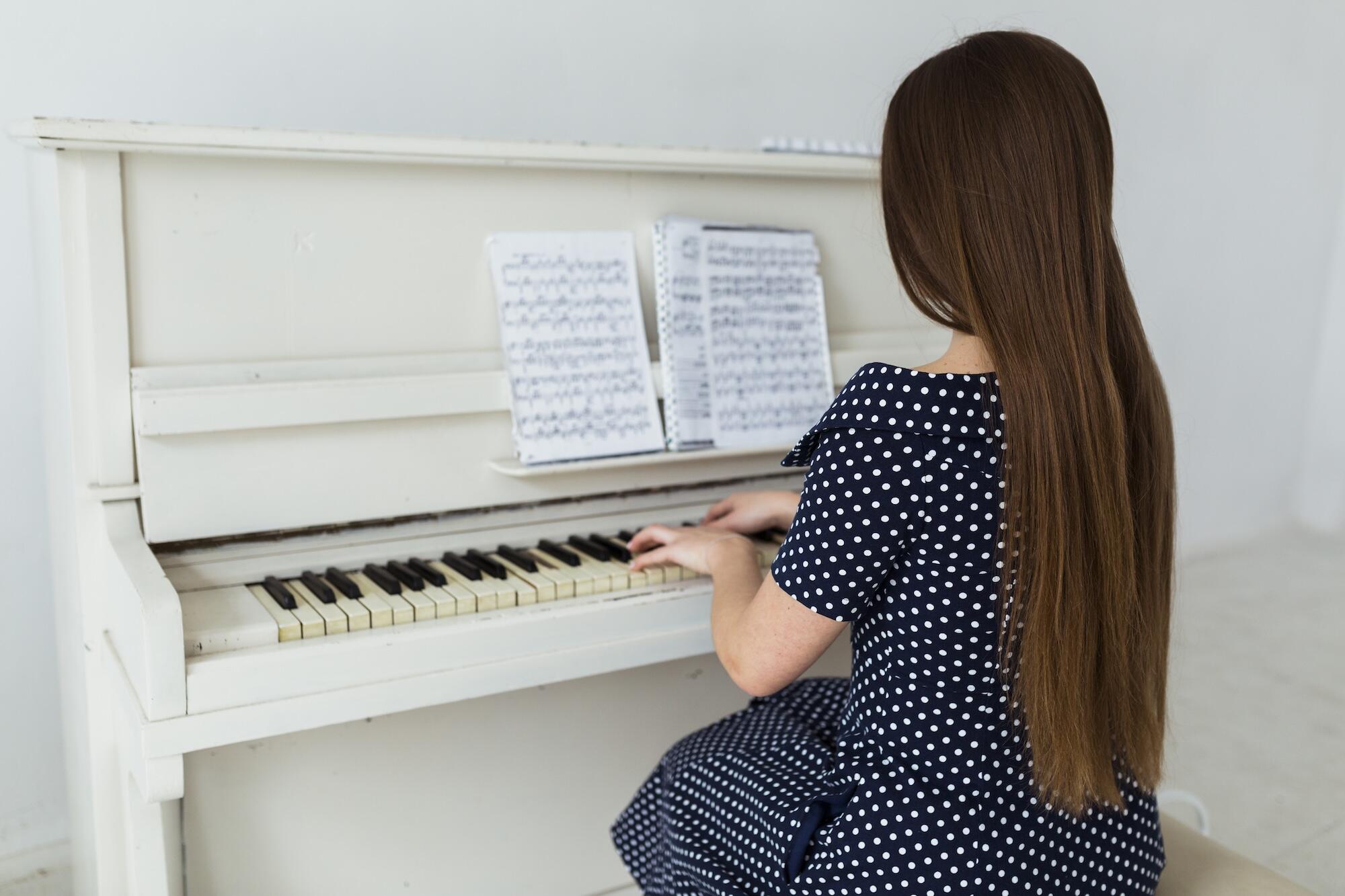 Une jeune fille est en train de jouer du piano