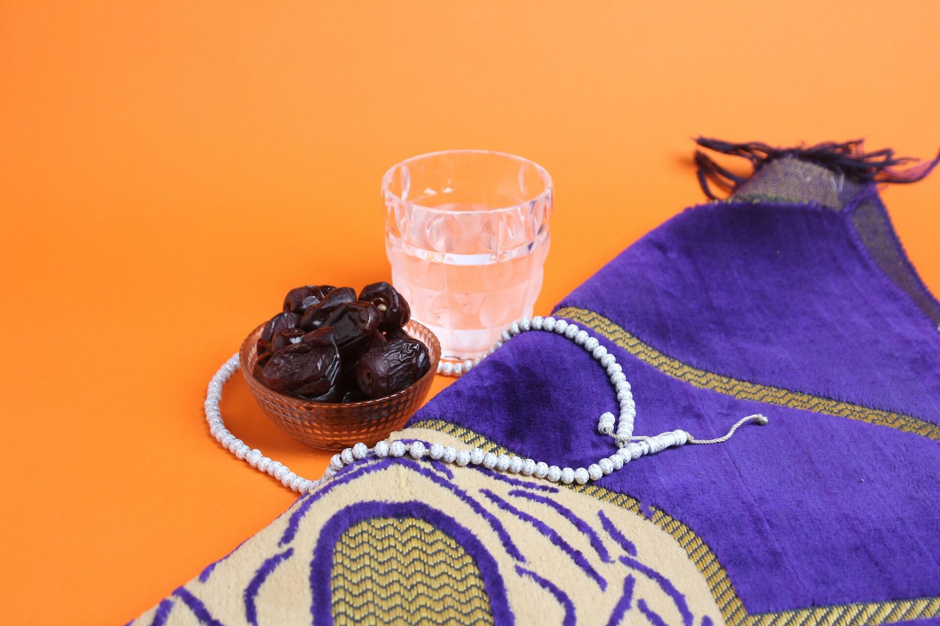 dates et verre d'eau sur fond orange