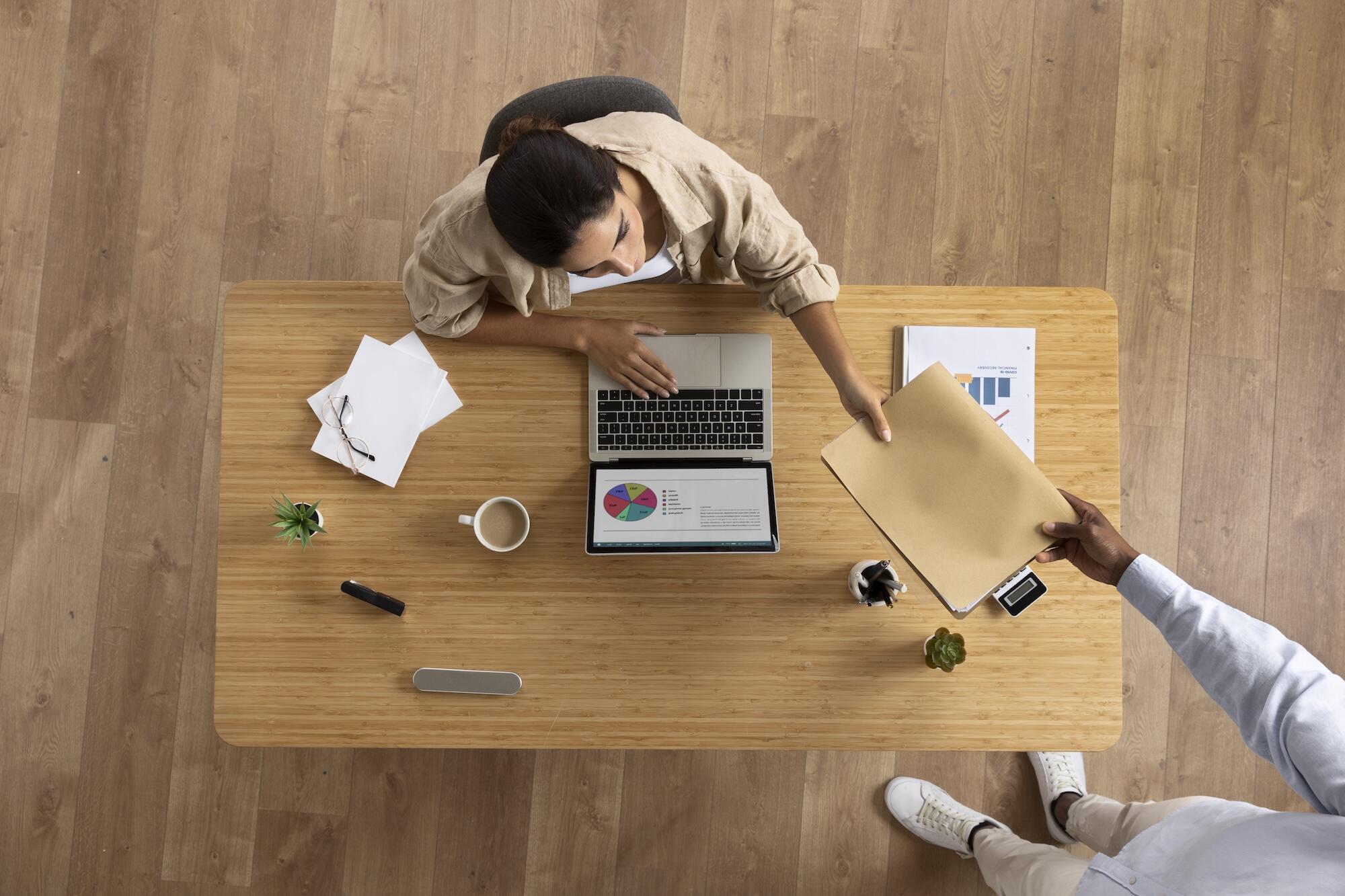 Une personne assise à un bureau vue de haut.