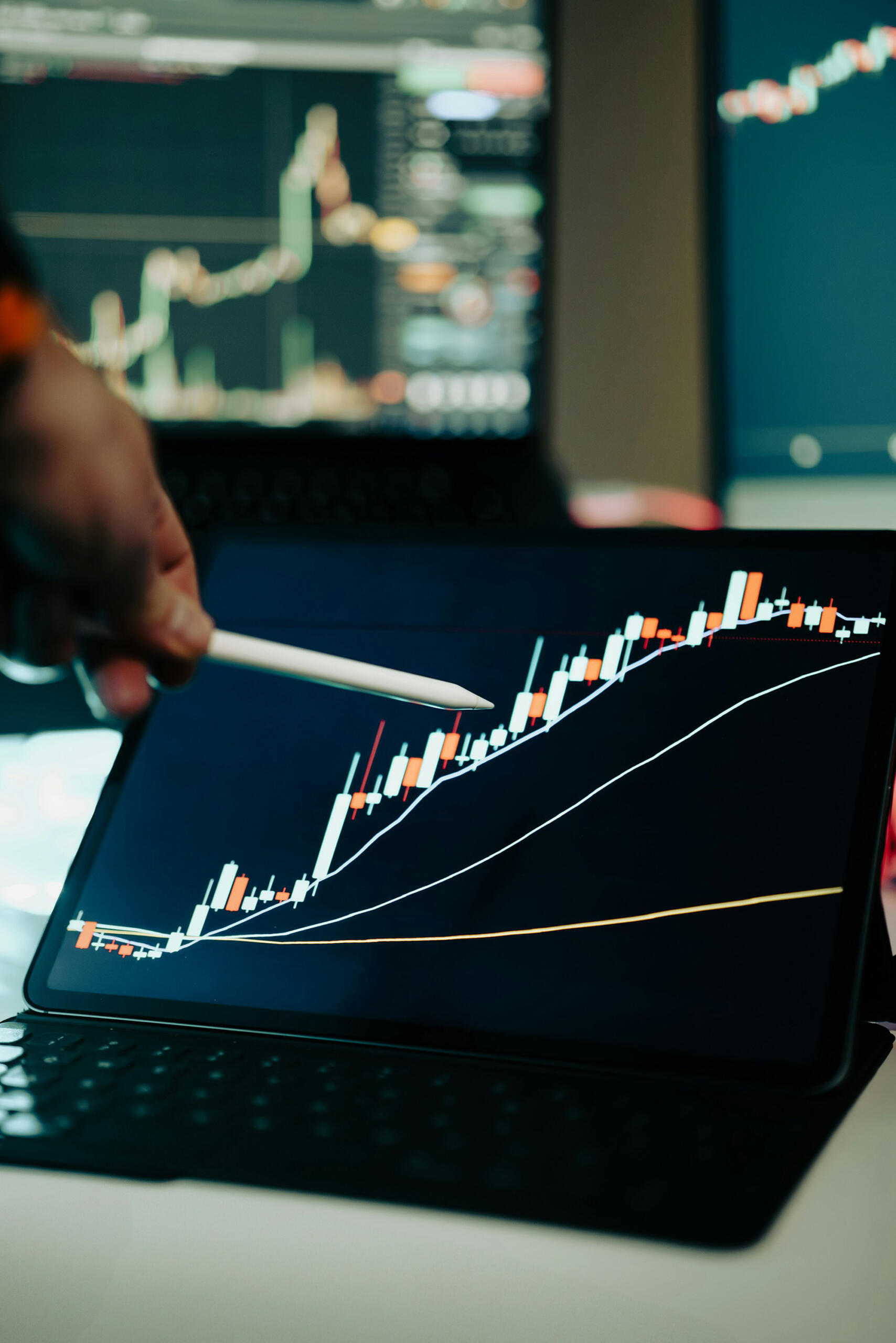 Un stylo montre un graphique financier sur un écran.
