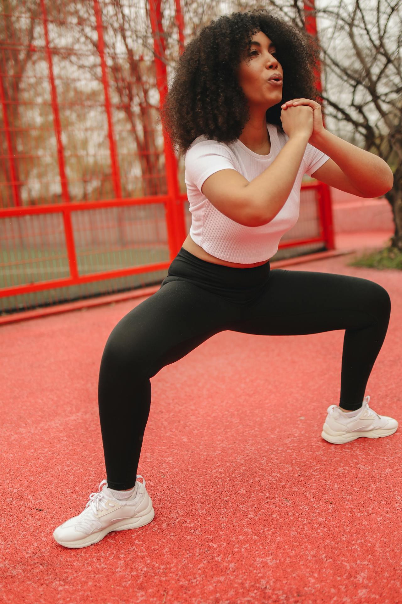 Jeune femme réalisant un squat sumo.
