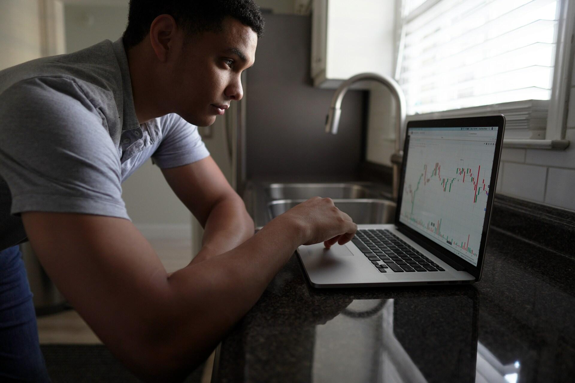 jeune homme en train de travailler sur son ordinateur sur un plan de travail