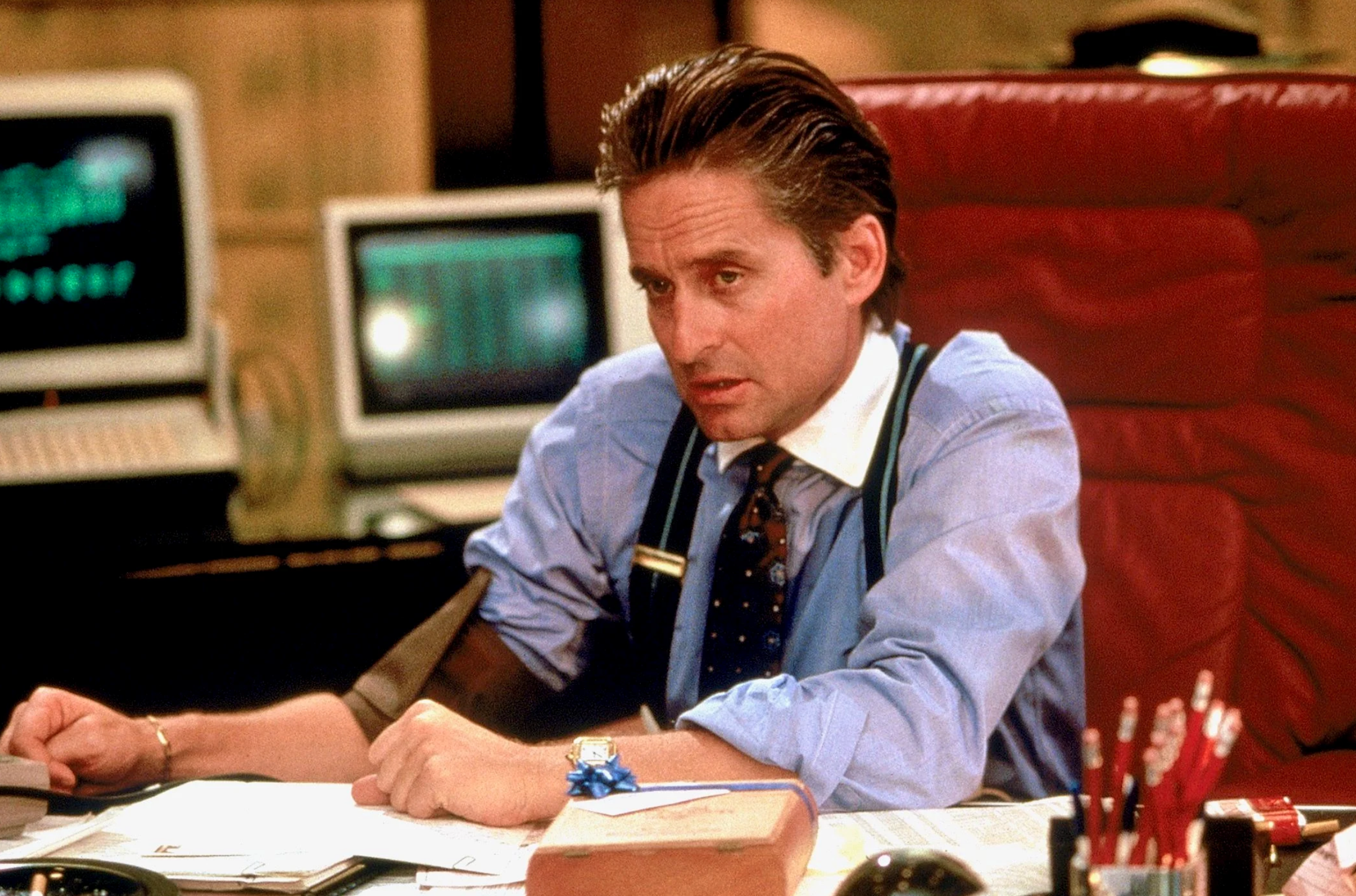 Michael Douglas assis à son bureau dans le film Wall Street
