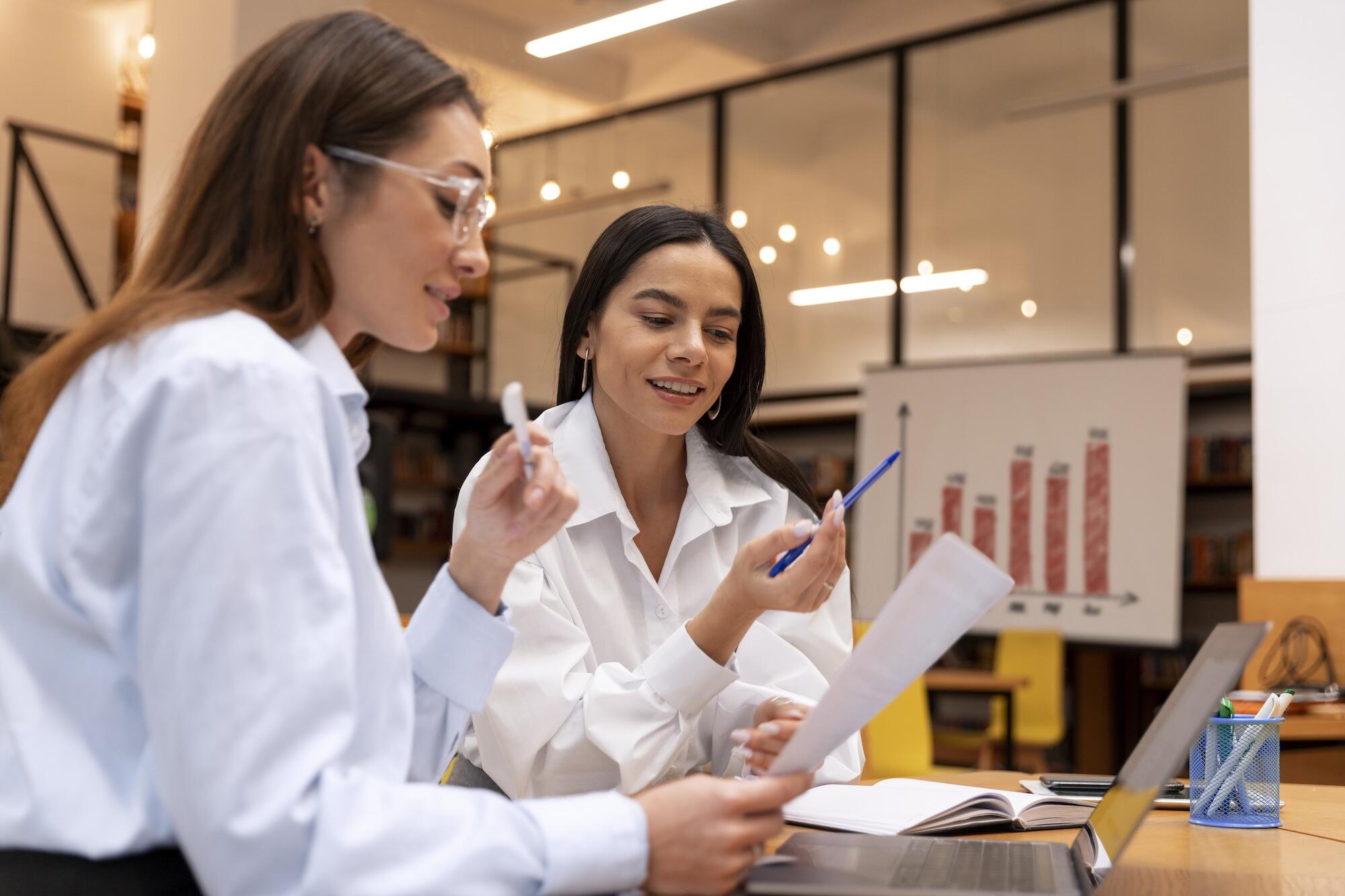 Deux femmes sont en train de travailler ensemble.