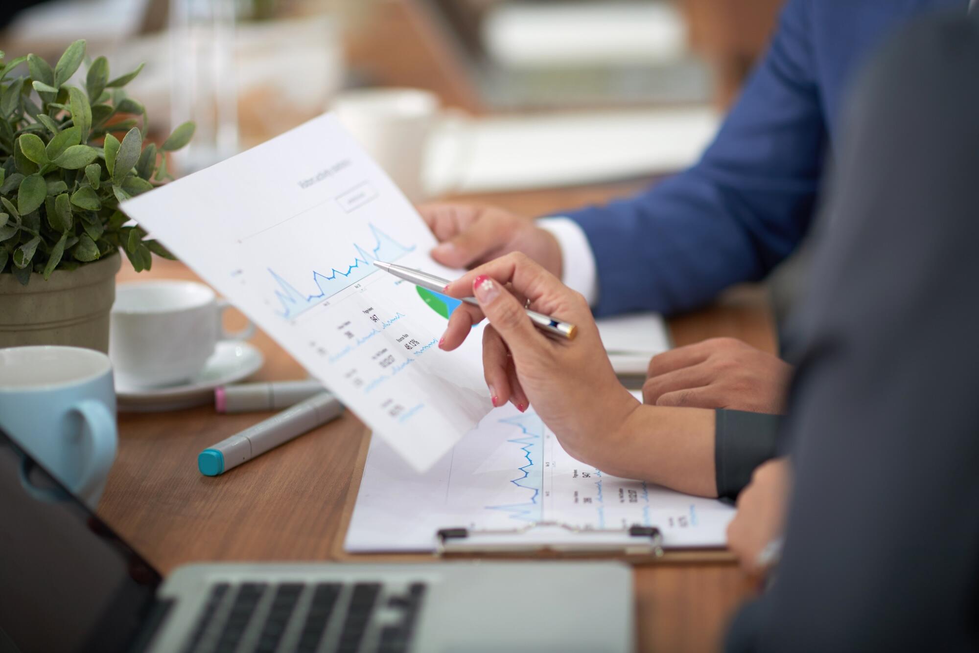 Des professionnels sont en train d'analyser une feuille avec des graphiques.