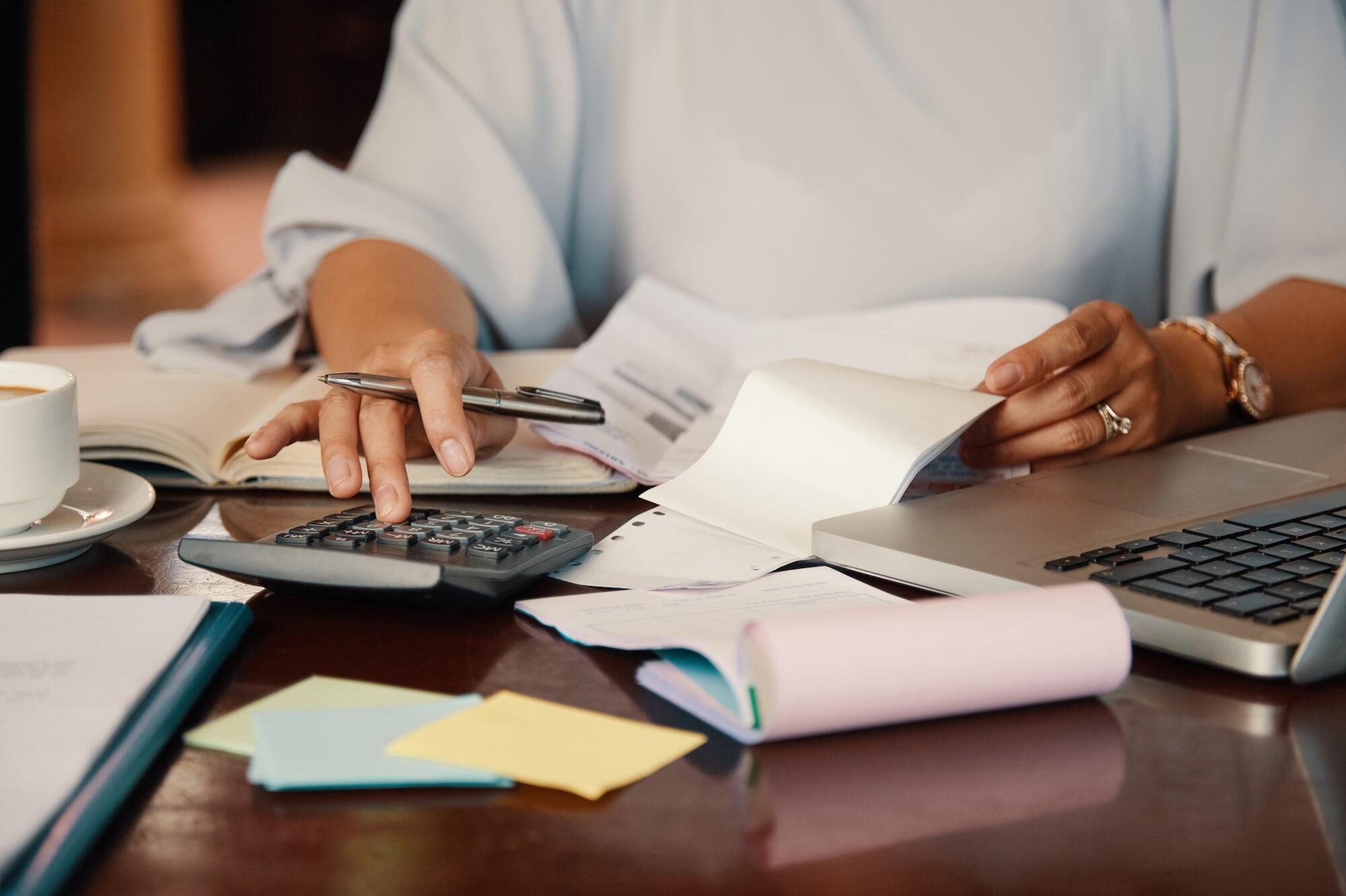 Une personne est en train de taper sur une calculette.