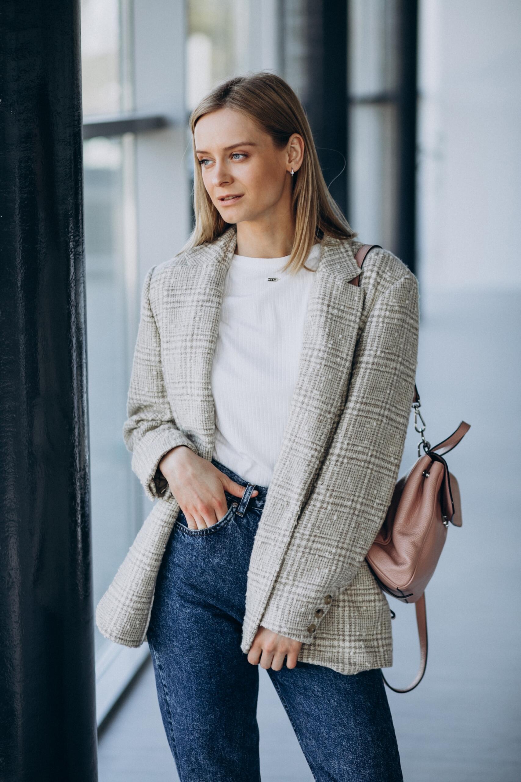Une jeune femme porte une veste et un sac
