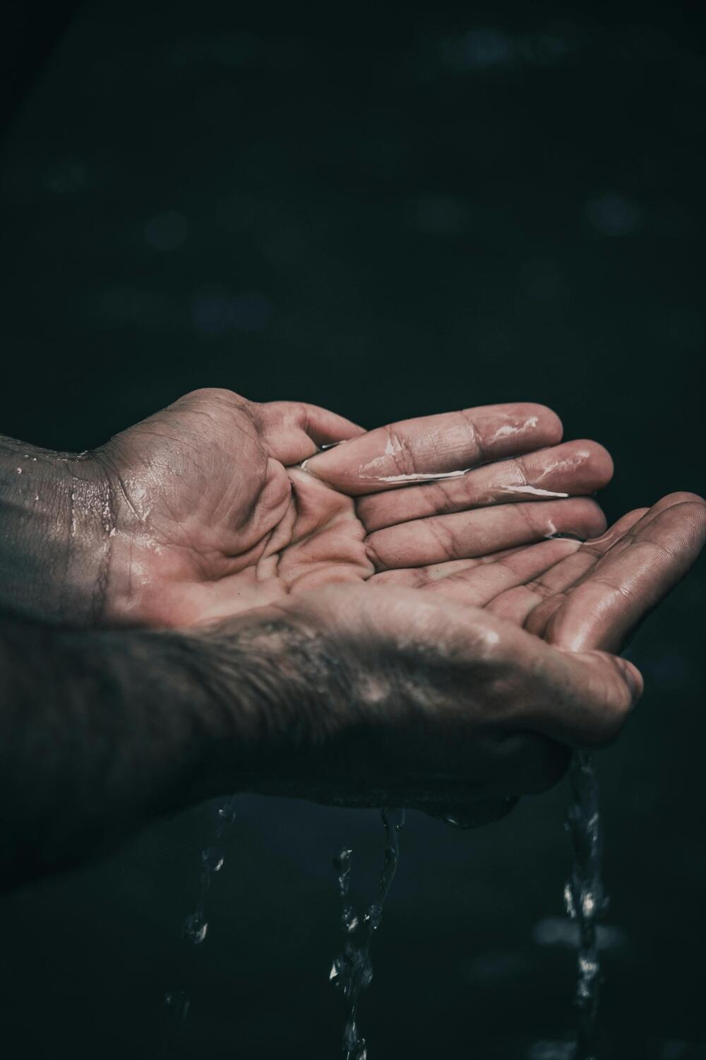 Des mains tentent de contenir de l'eau