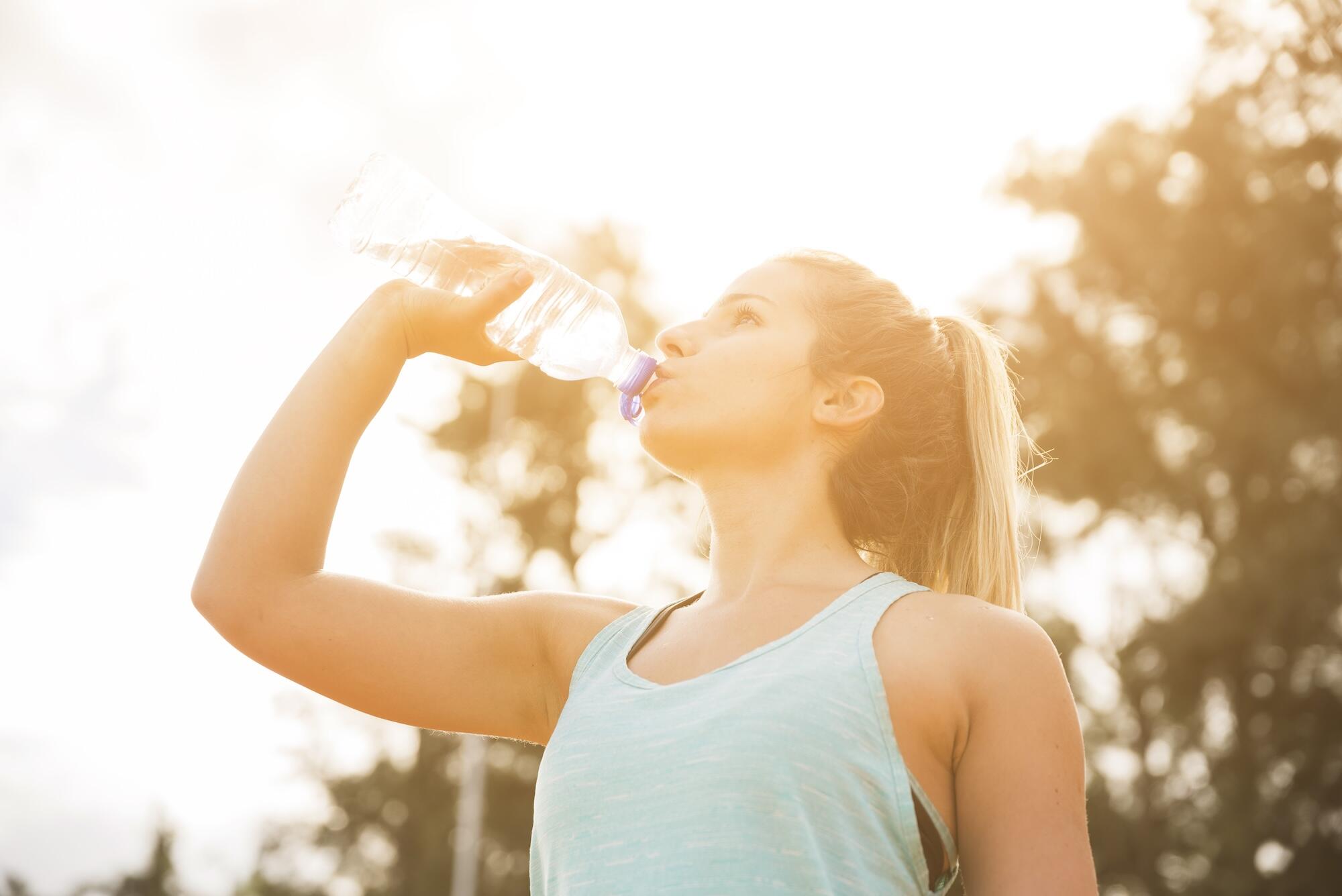 Une jeune femme boit de l'eau