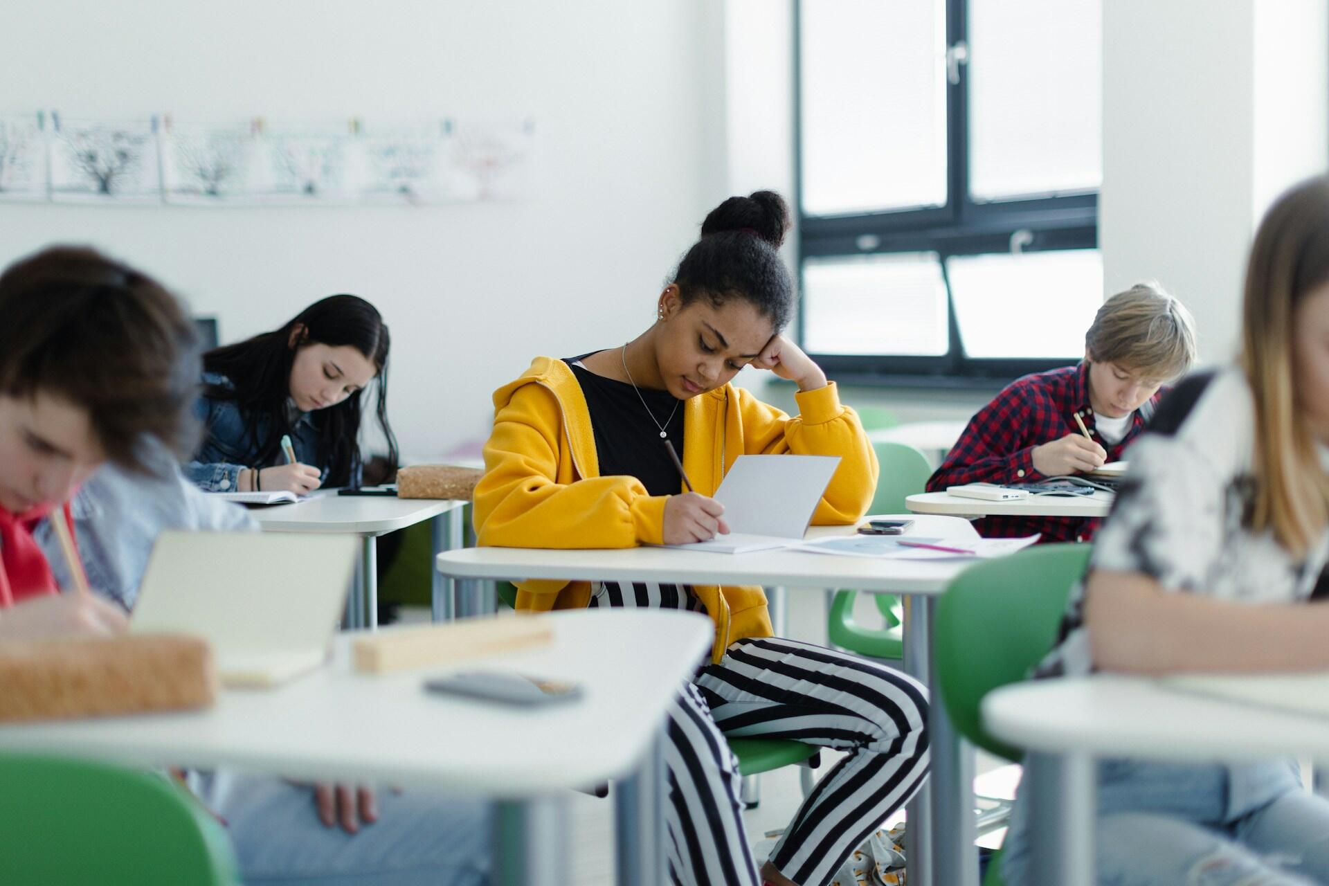 Une adolescente qui fait un devoir dans une salle de classe