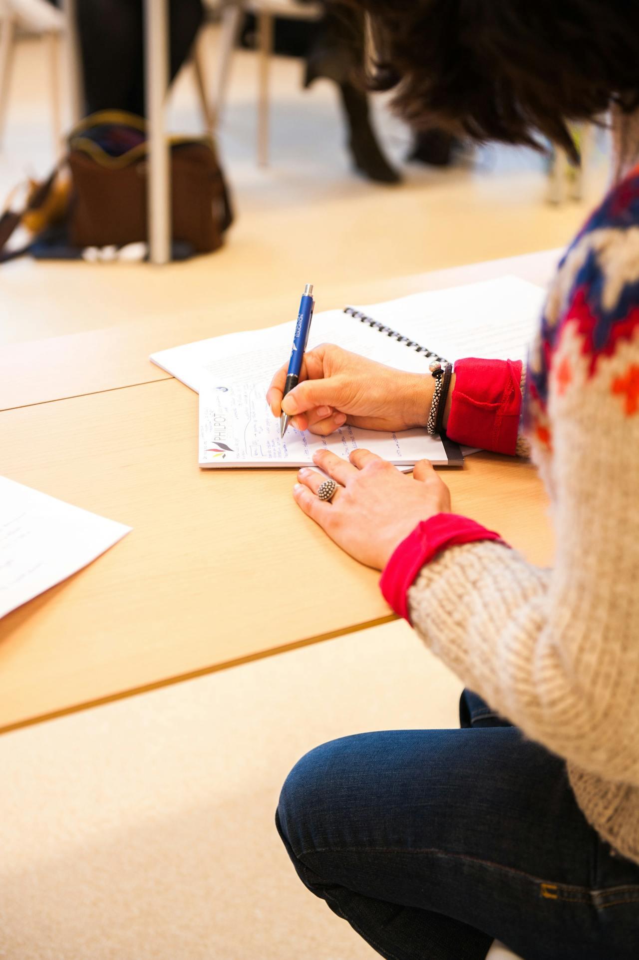 Jeune femme prenant des notes assise à un bureau