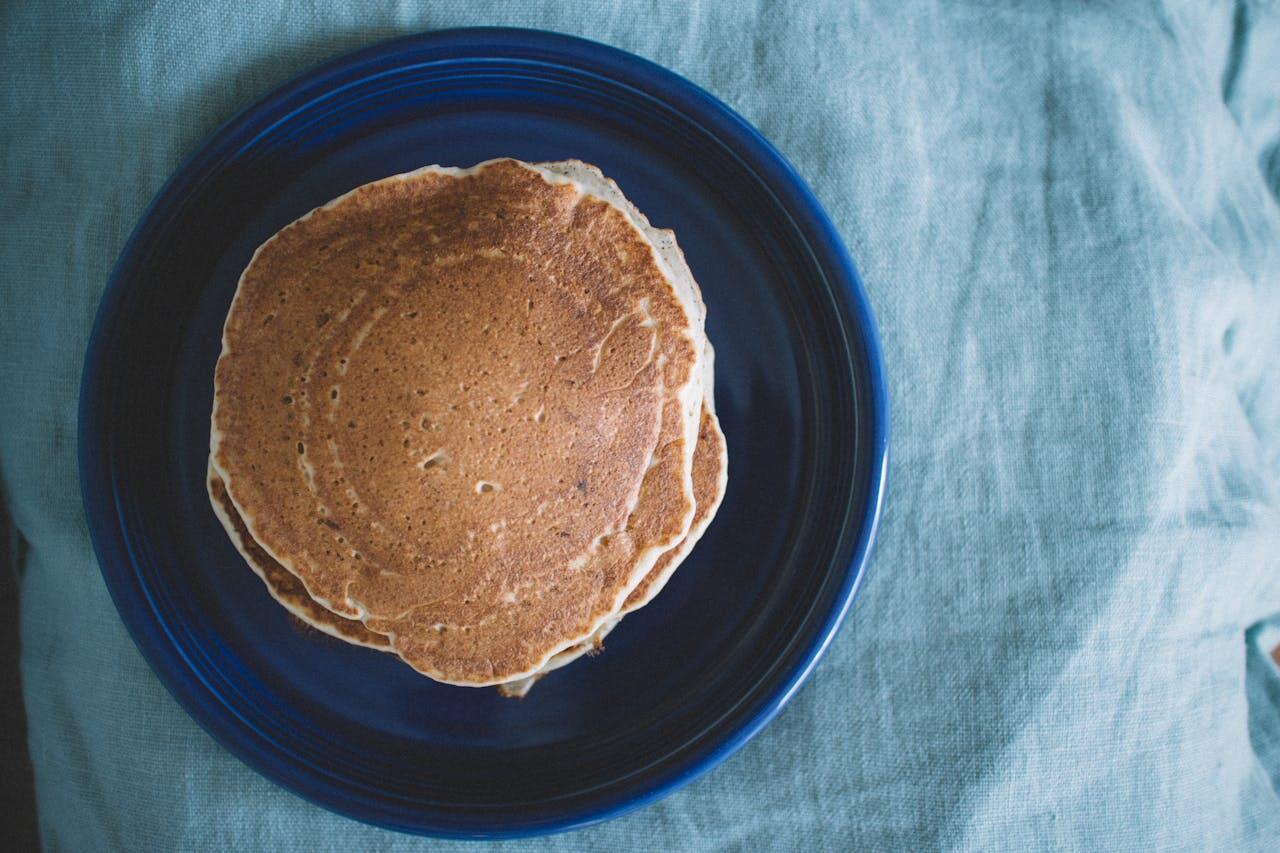 Pile de pancakes vue d'en haut dans une assiette bleue. 