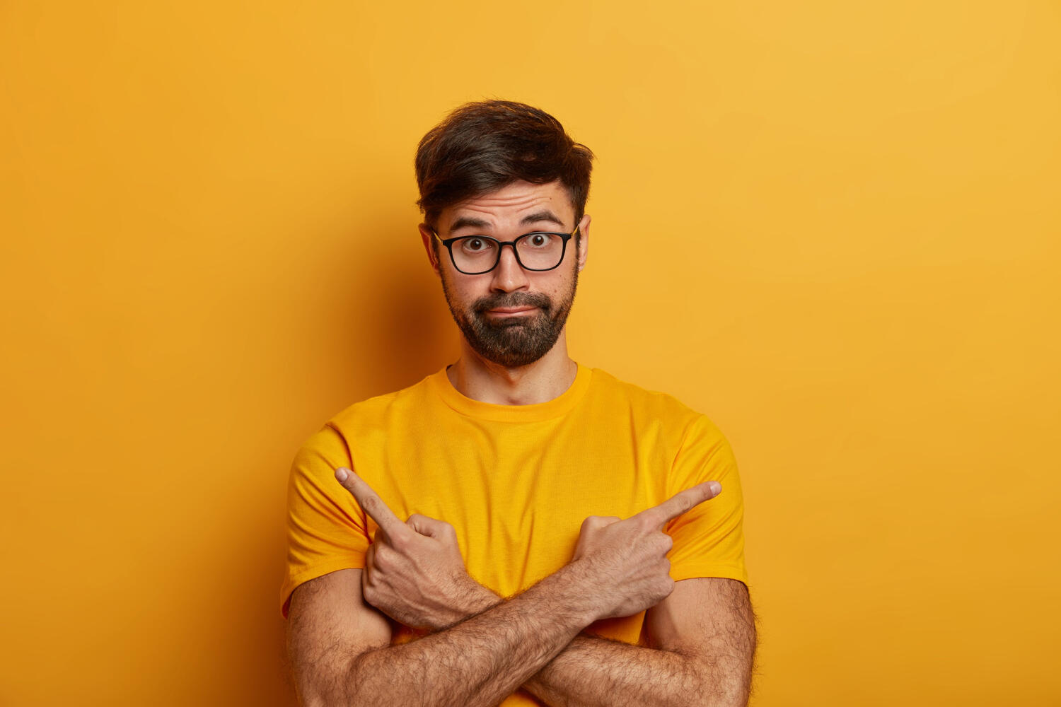 Homme sur fond jaune pointant du doigt deux directions différentes. 