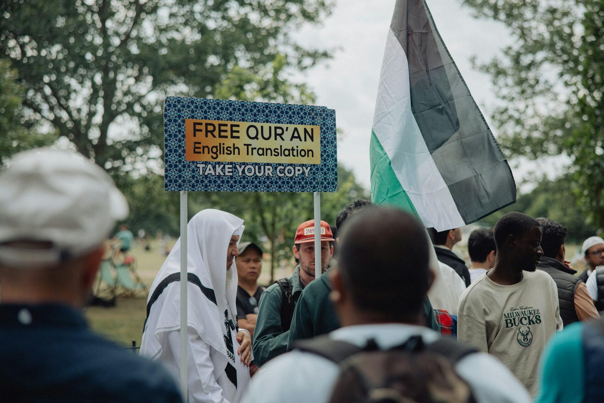 personnes dans la rue en train de distribuer des Corans en anglais 