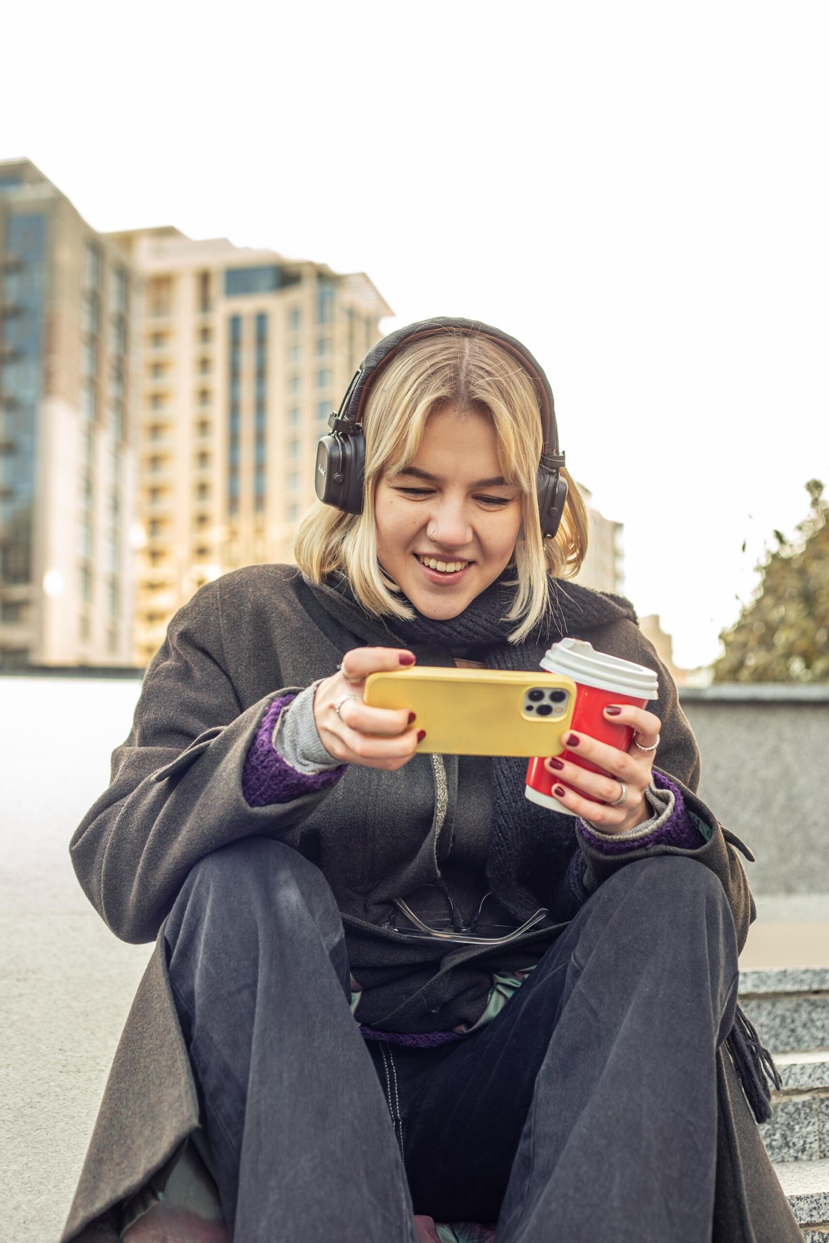 Une jeune femme joue à des jeux sur son smartphone.
