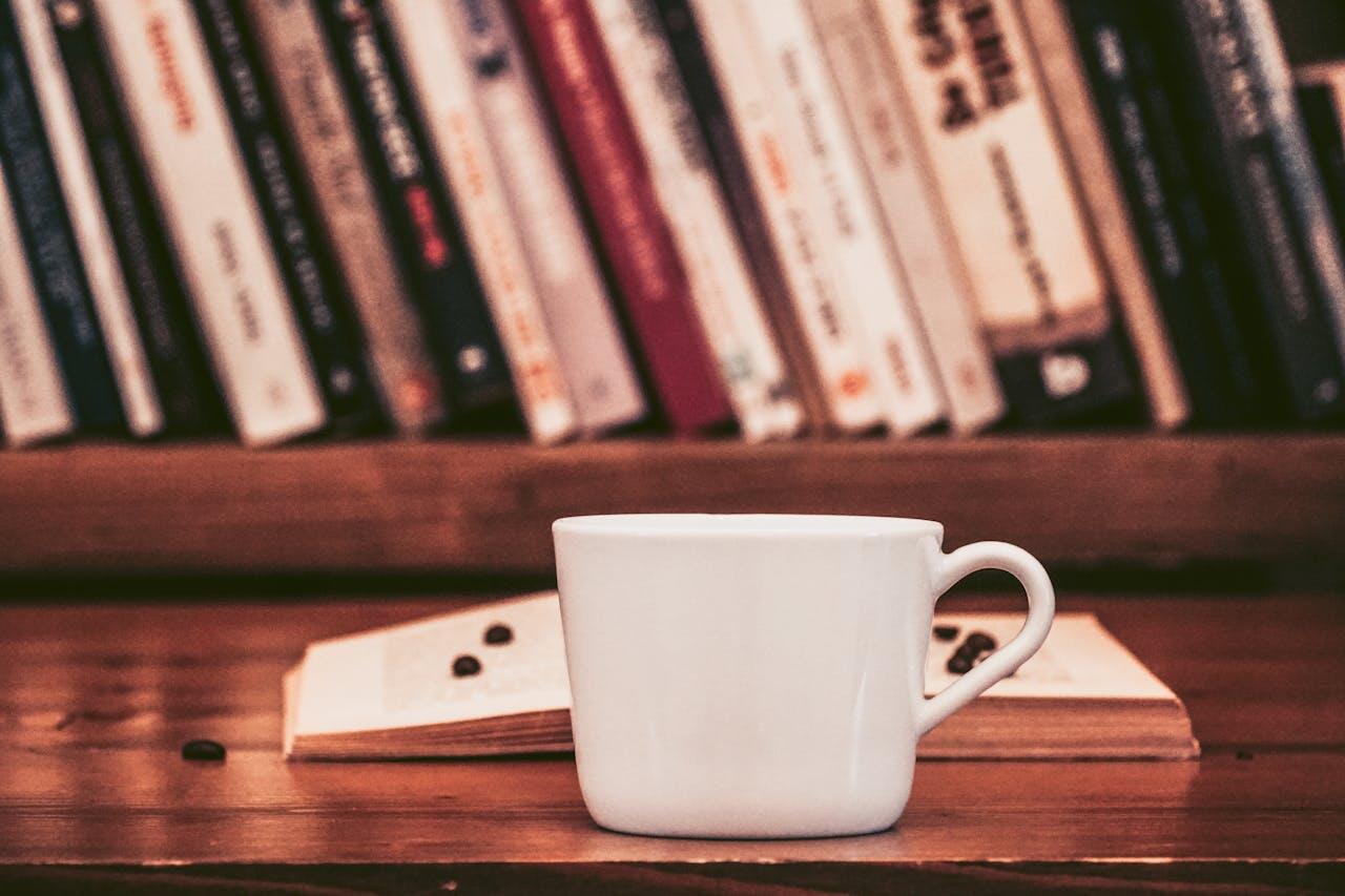 Un café posé sur une table devant des livres. 