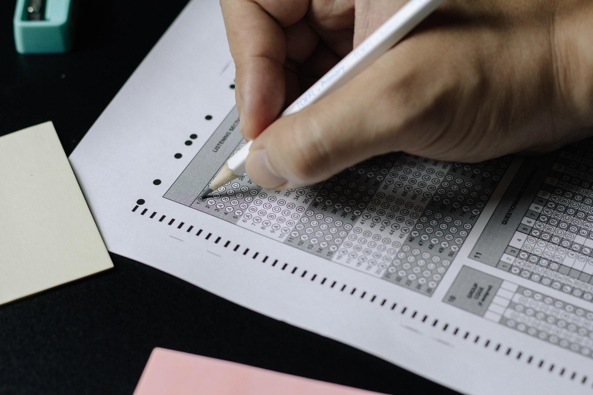 A test answer sheet with bubbled spaces that a student marks out with a pencil.