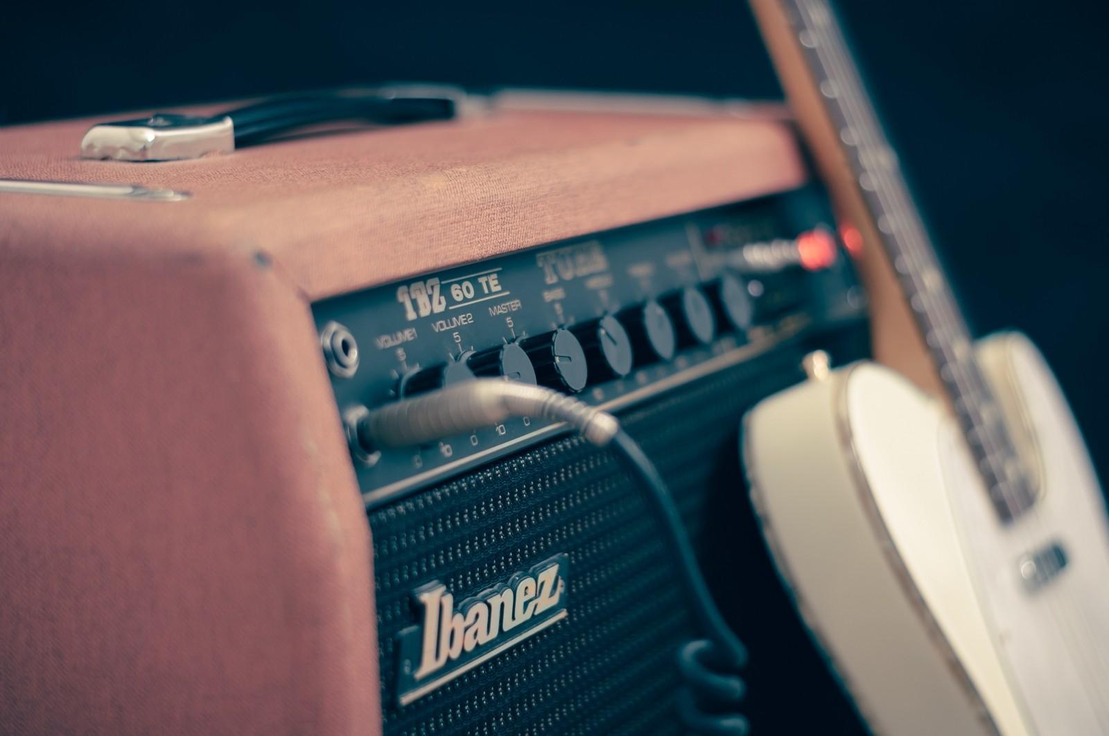 An electric guitar leans against an amplifier.