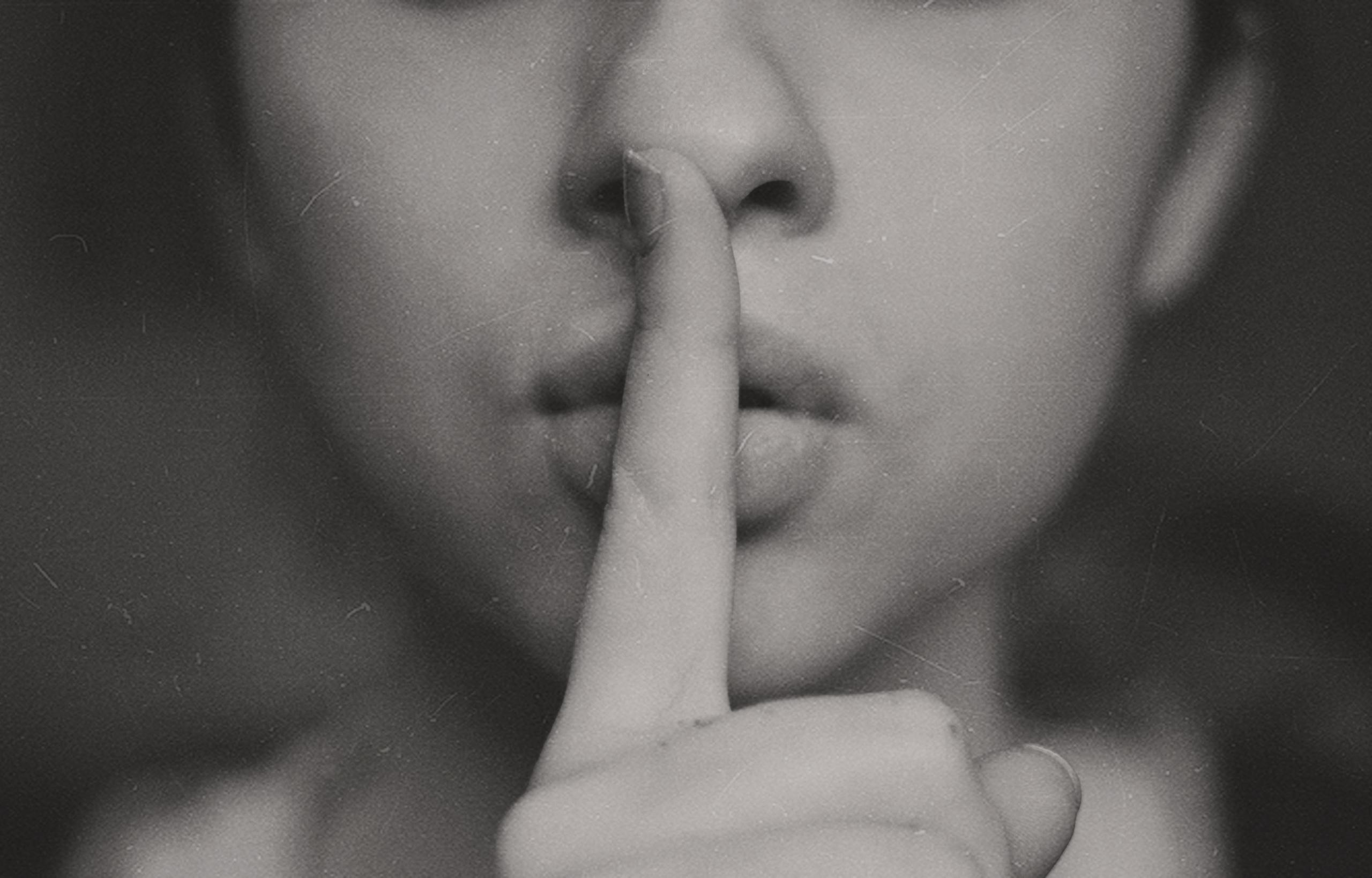 a woman with a finger over her lips