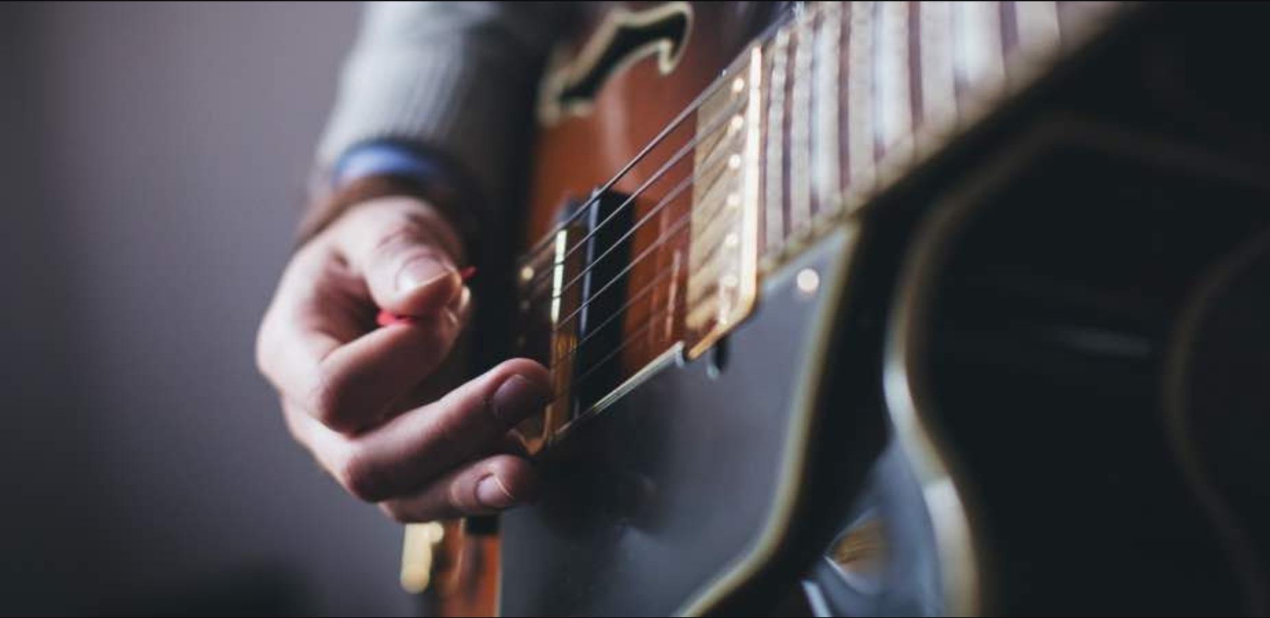 The body of a guitar as someone plays.