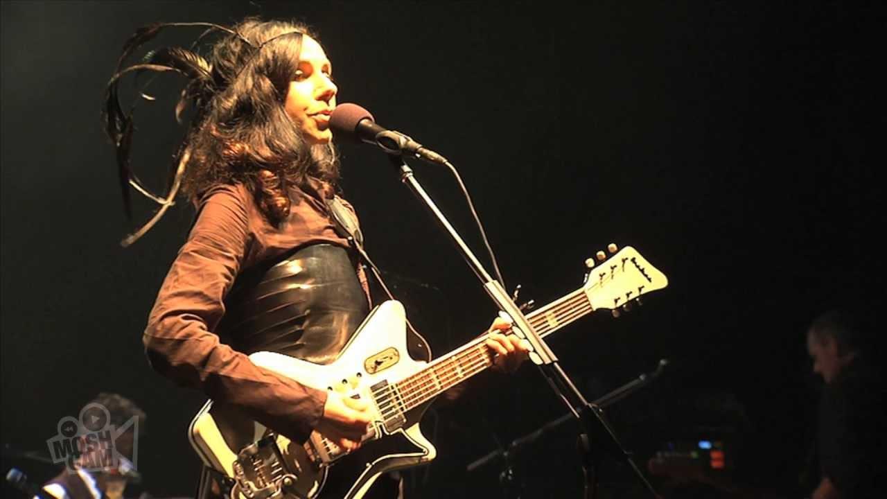 A woman onstage playing the guitar
