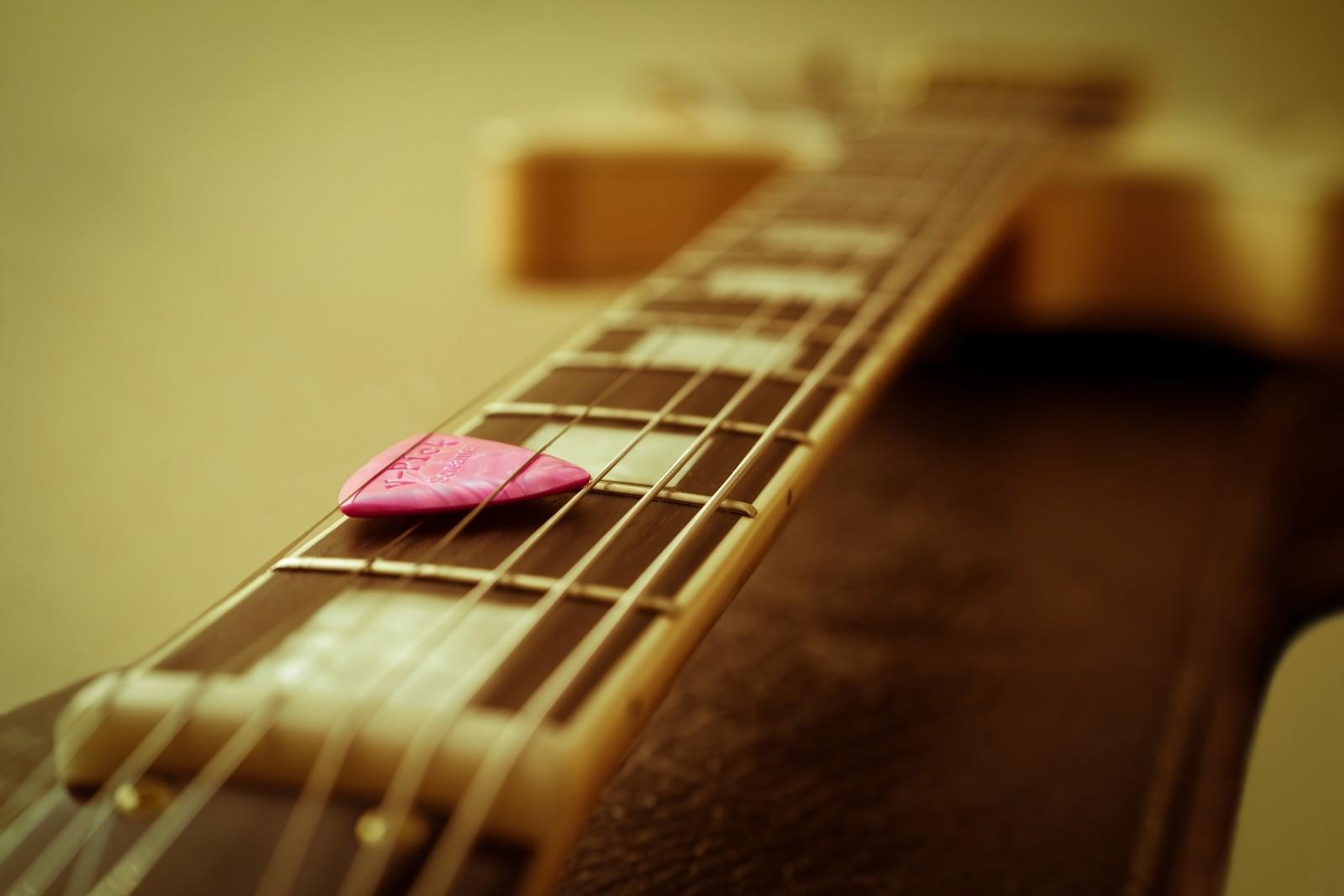 A guitar neck with plectrum