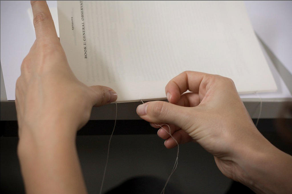 Sewing a book together.