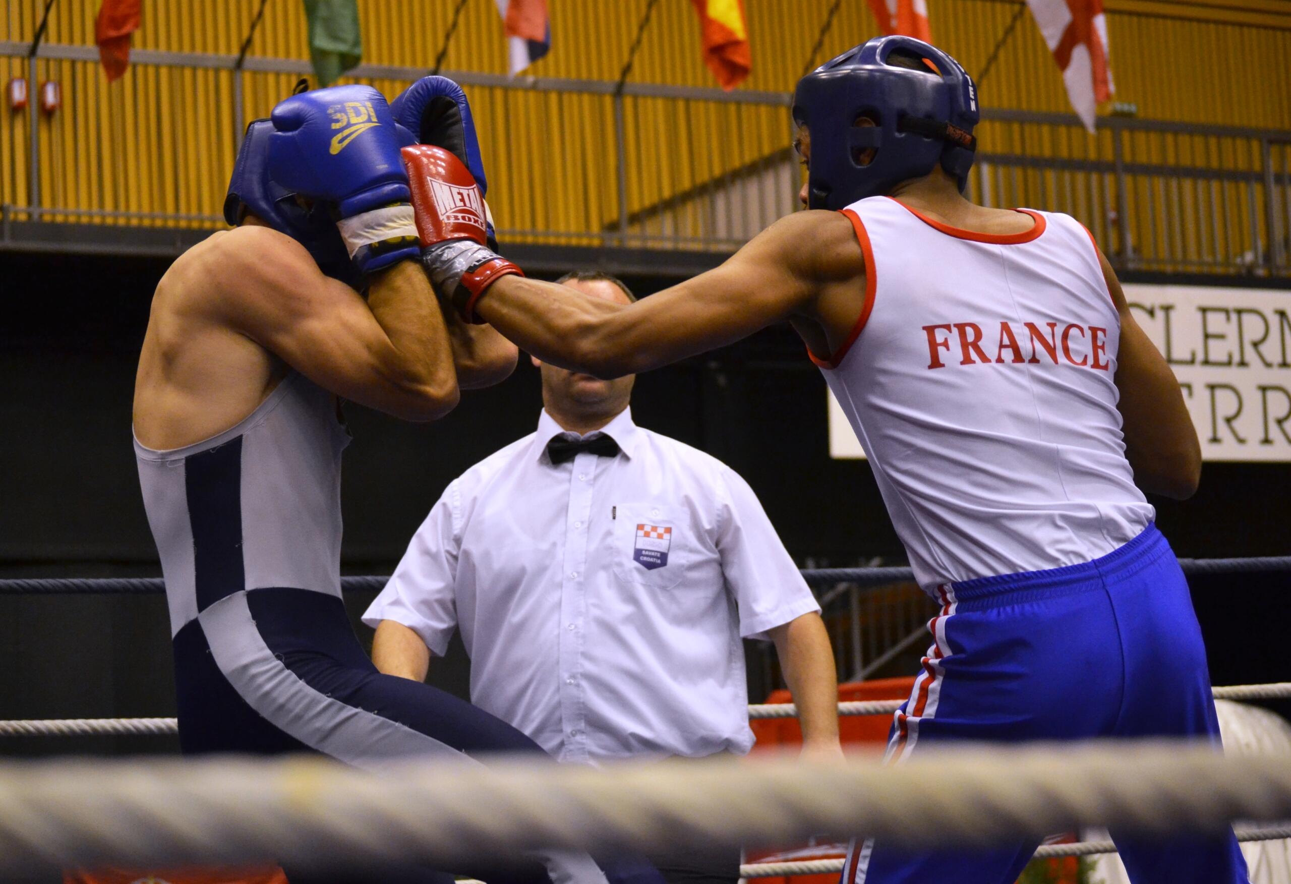 Two fighters in head gear in boxing ring 