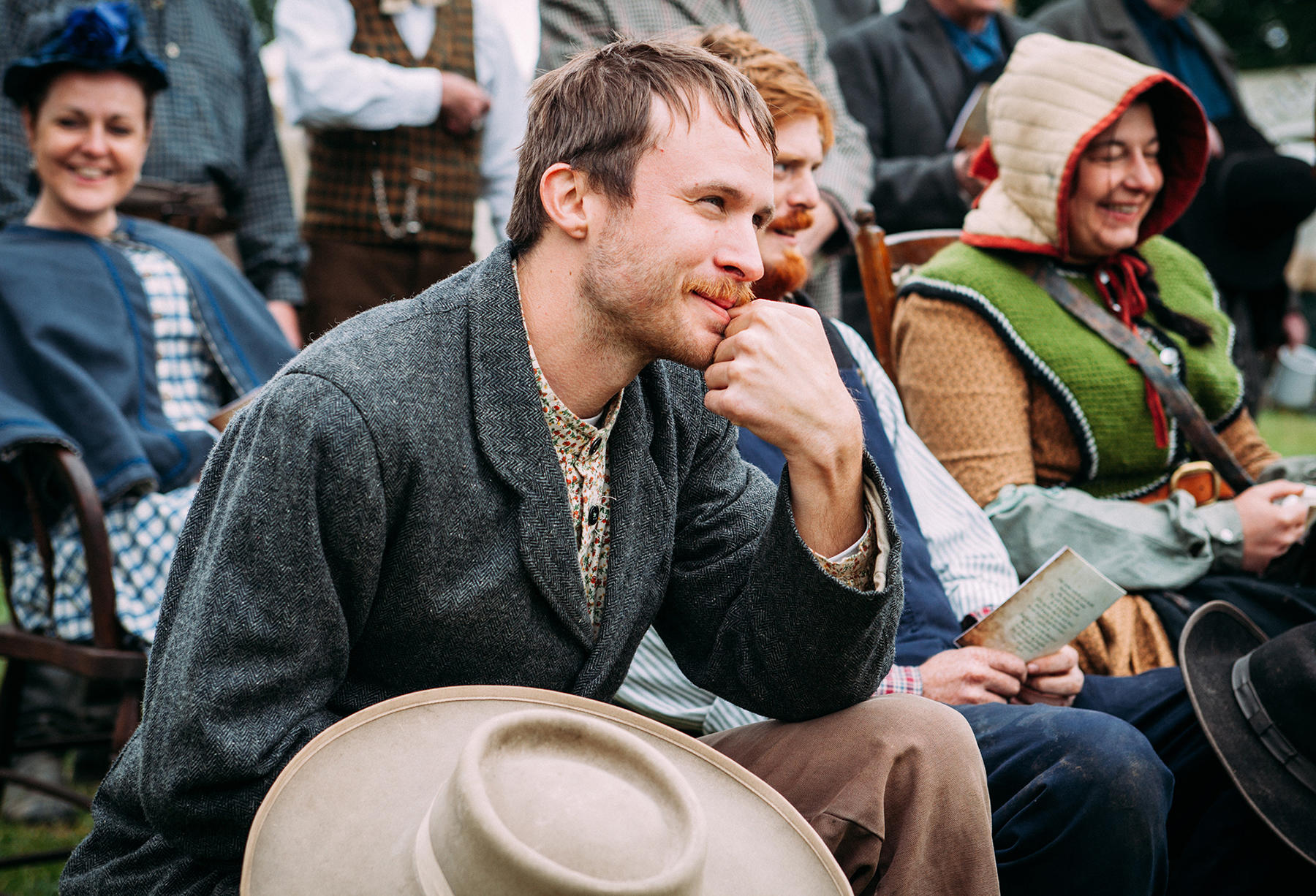 Actors and actresses in costume wait for their scene.