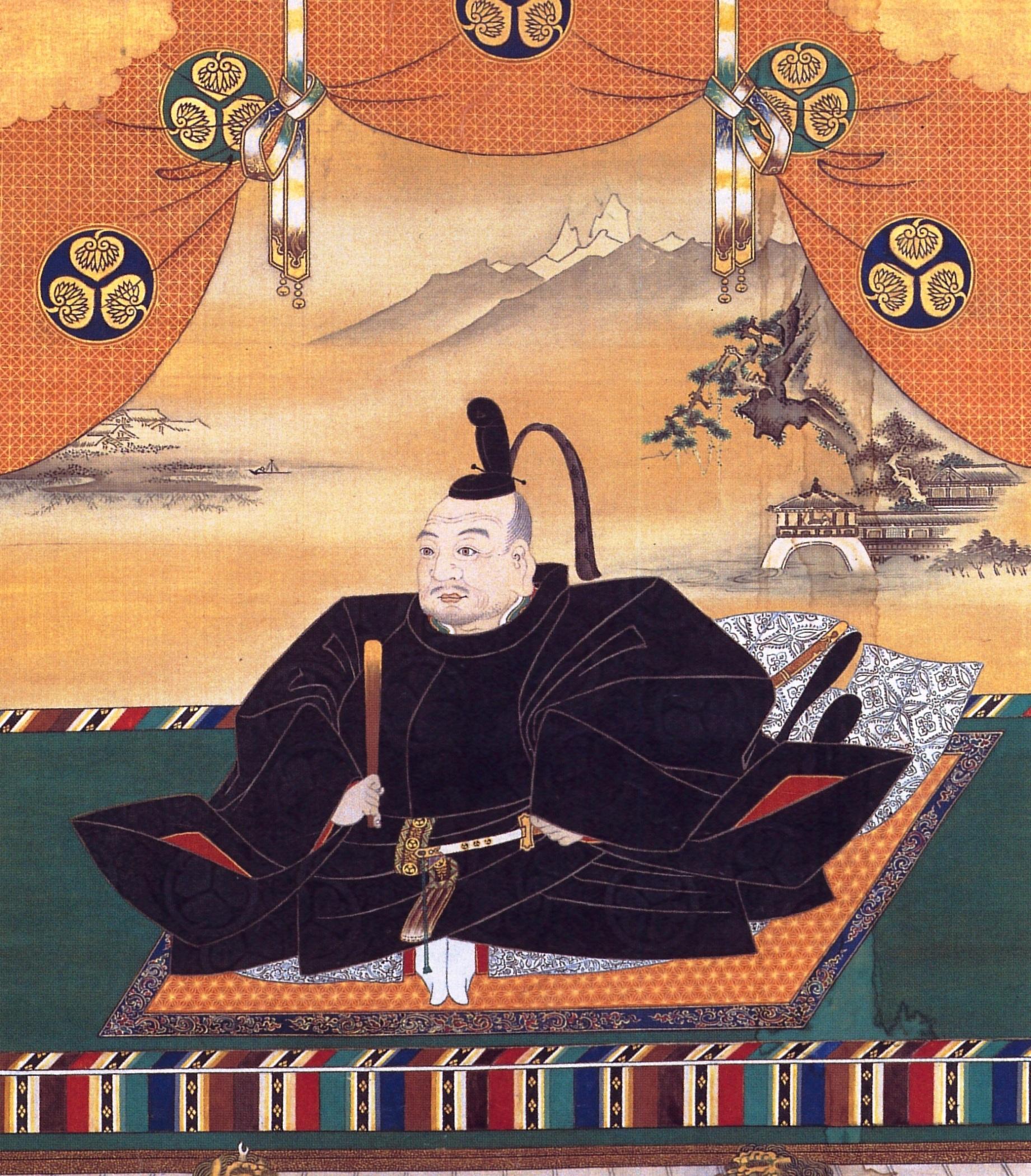 A seated figure in traditional black robes, holding a staff.