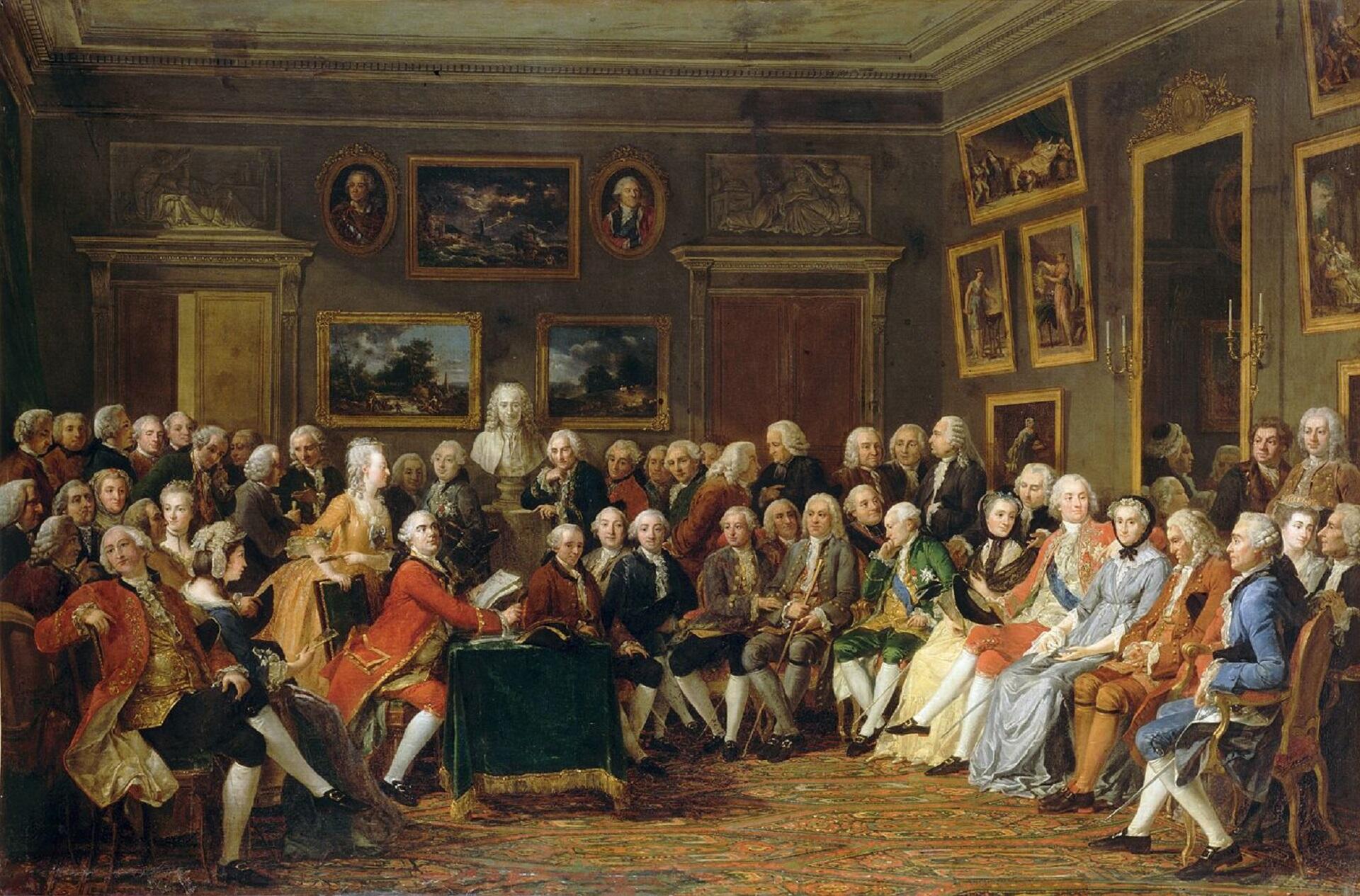 A group of people sitting close together in a large room.