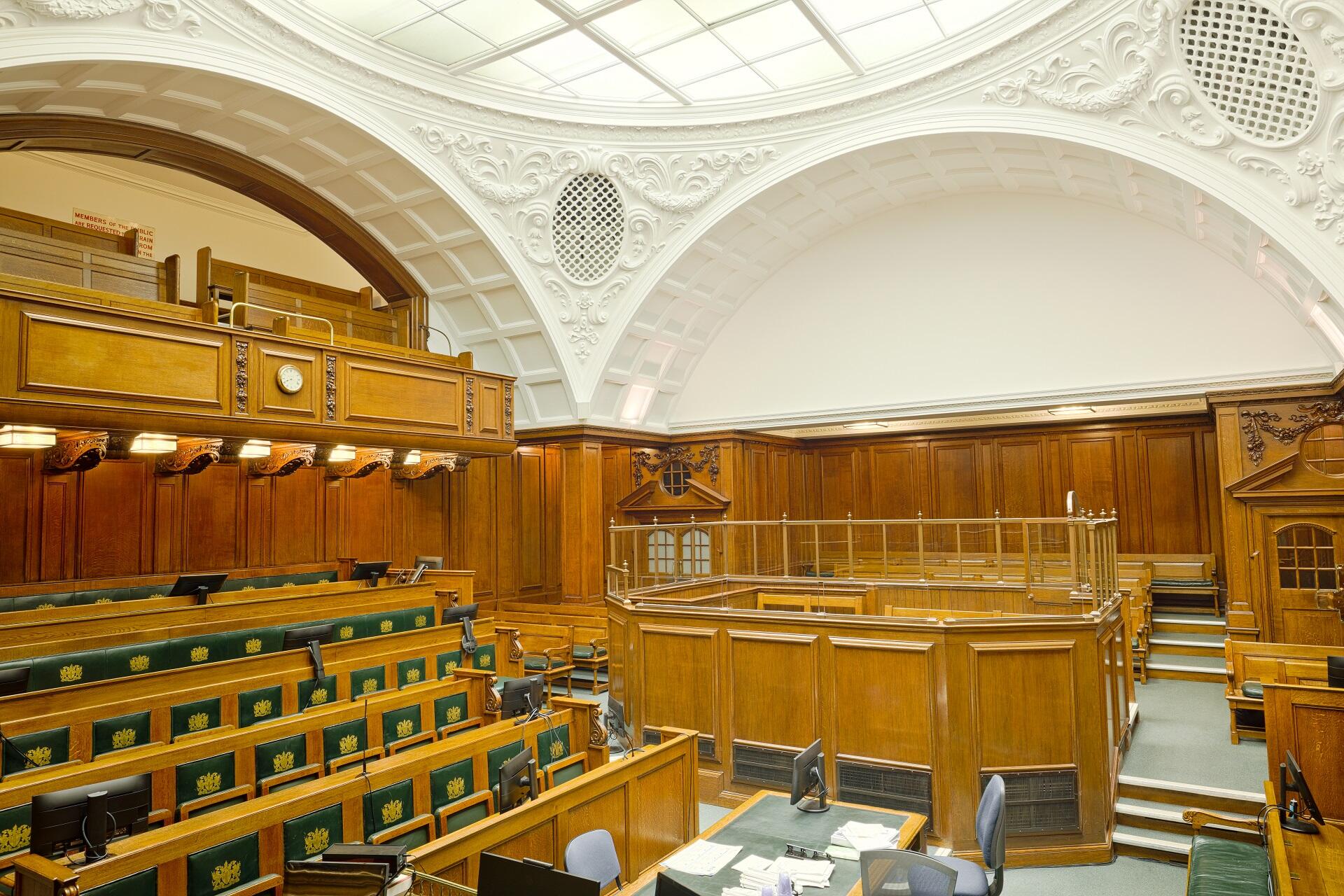 A large chamber with wooden benches and a white domed ceiling. 