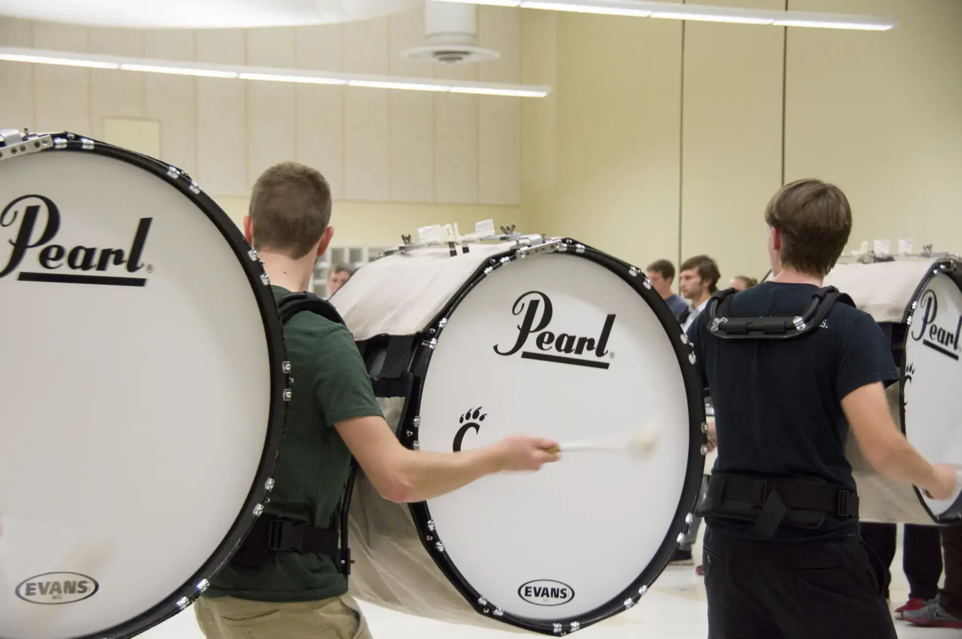 people standing in a line playing pearl bass drums